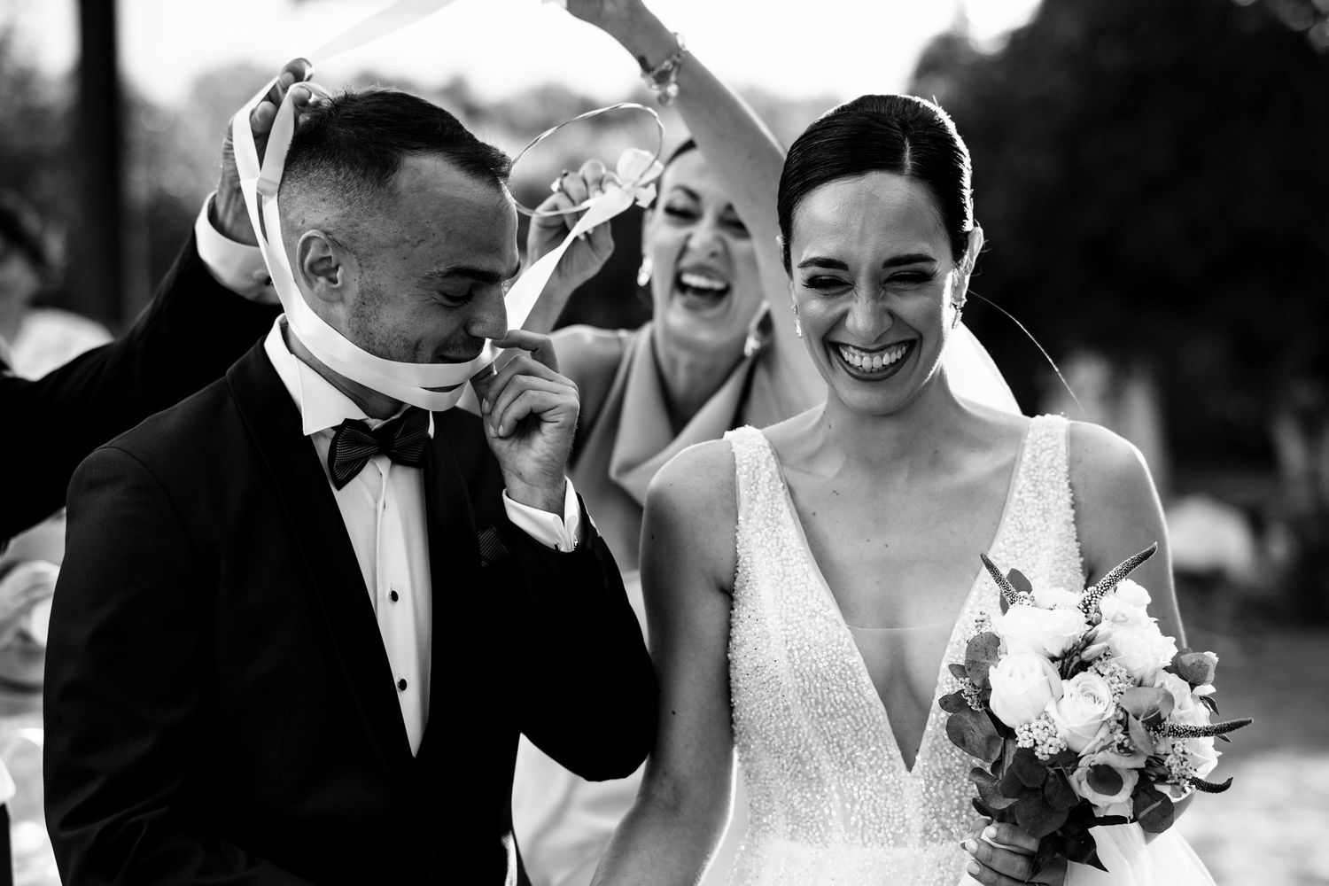 Candid black and white wedding moments showing joyful laughter and celebration.