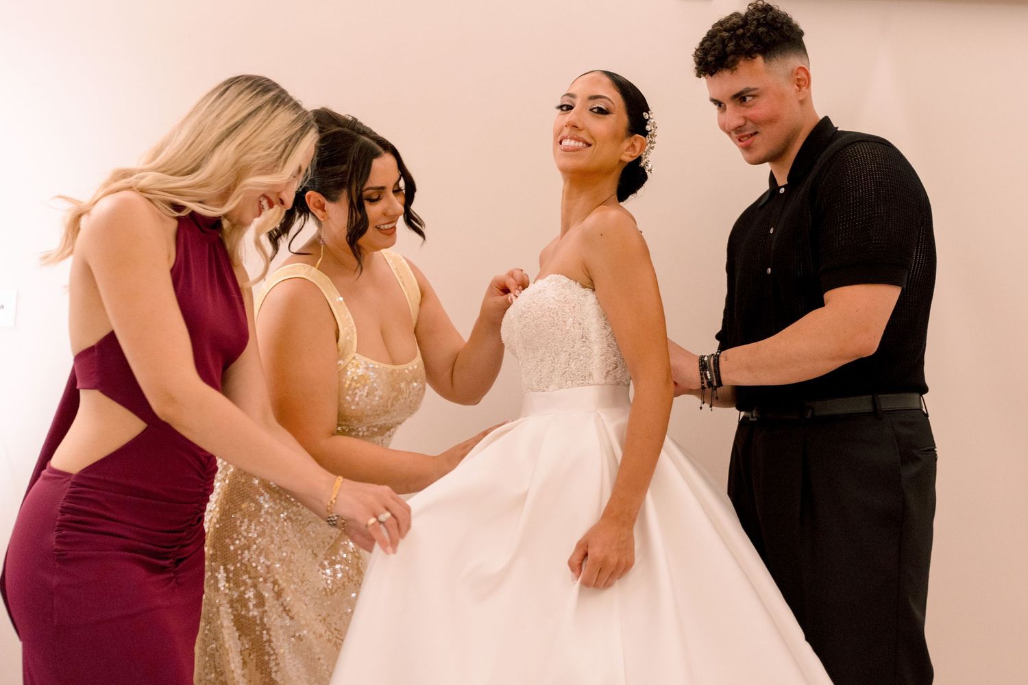Wedding party members dance together in burgundy and neutral colored attire.