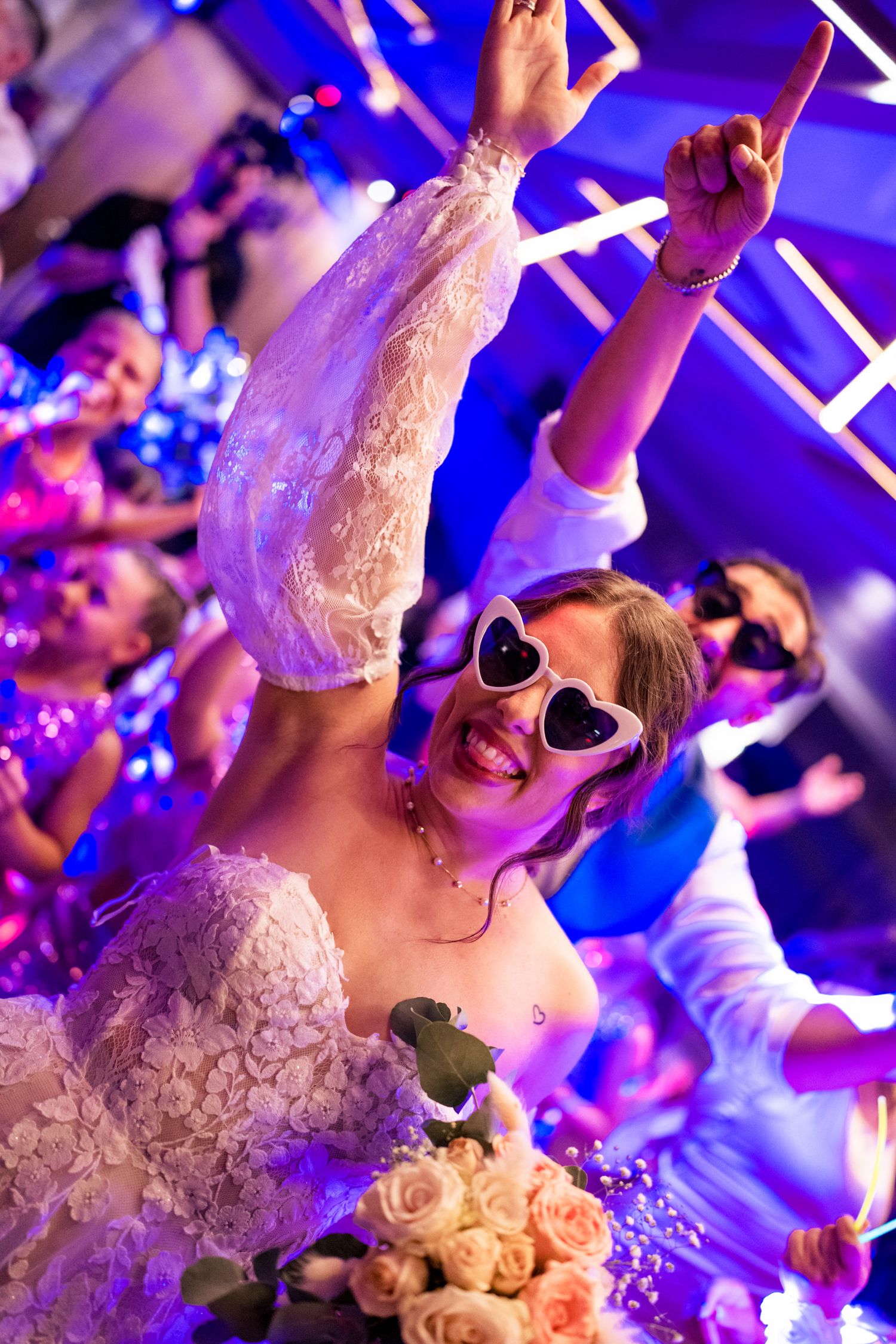 Joyful celebration on the dance floor with heart sunglasses and purple lighting effects.