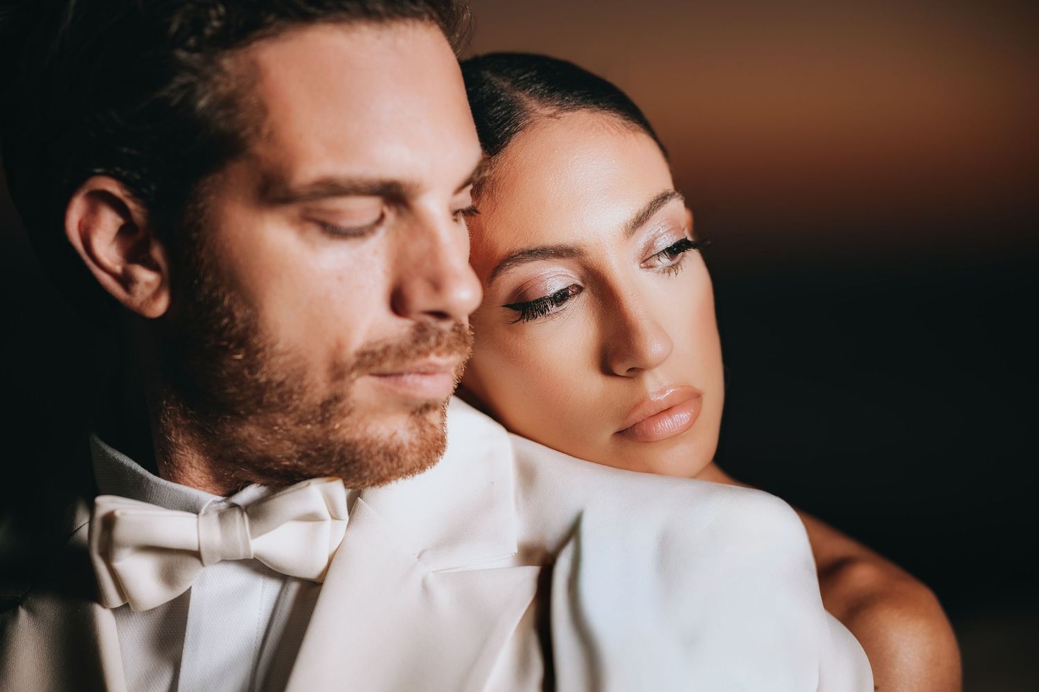 Artistic black and white wedding portraits capturing tender moments between newlyweds.