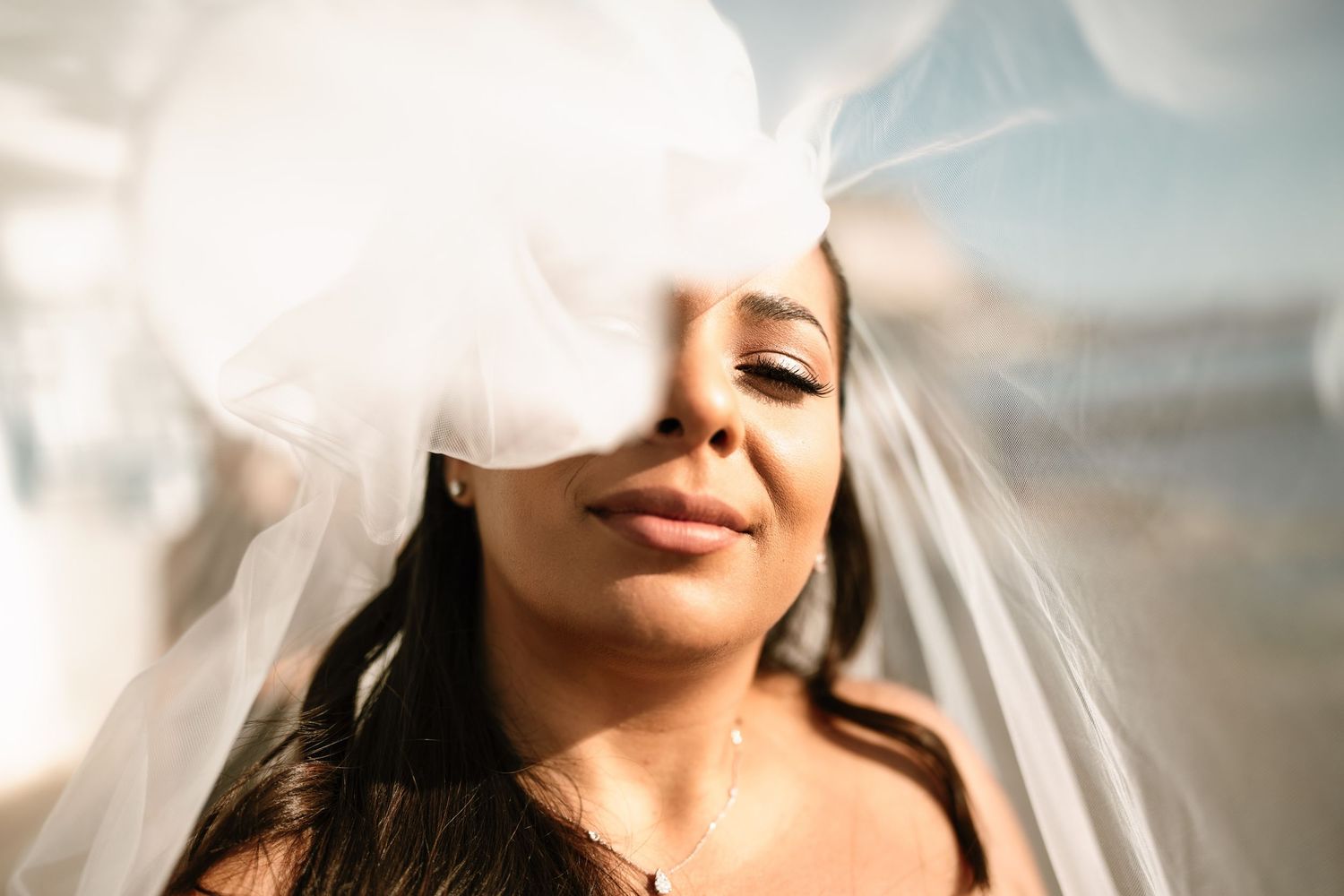 Close-up shots of a bride with flowing veil in natural light.