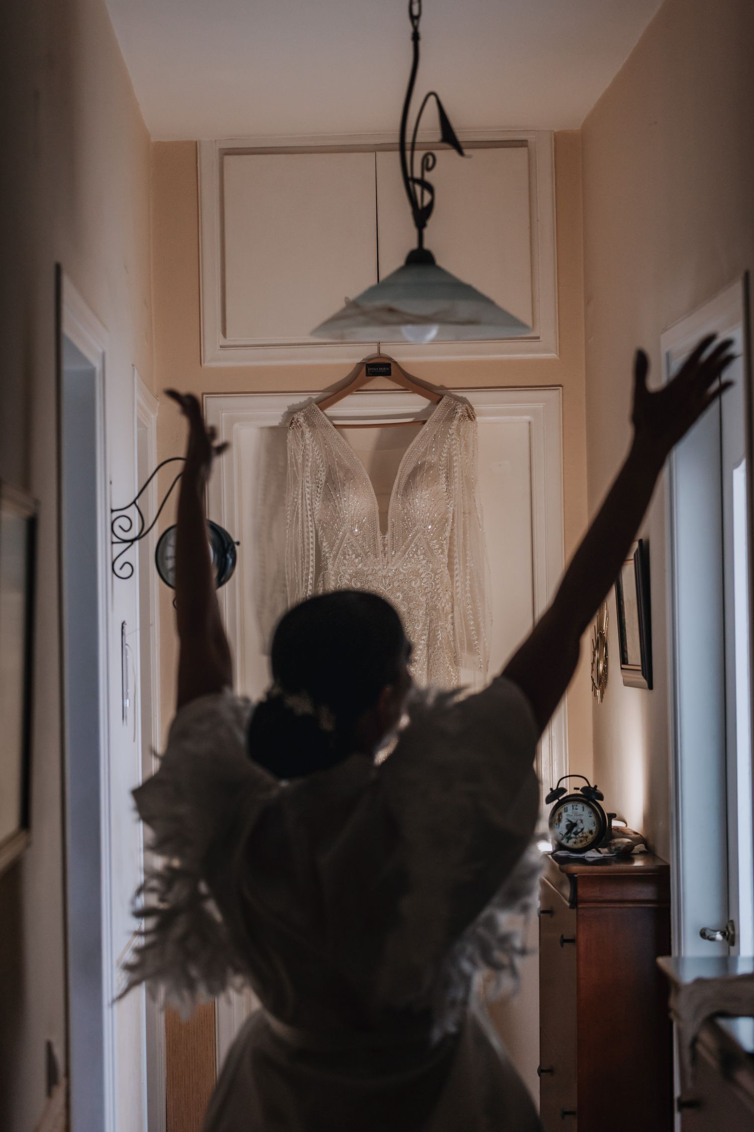 Silhouettes of people celebrating with raised arms against a bright window background.