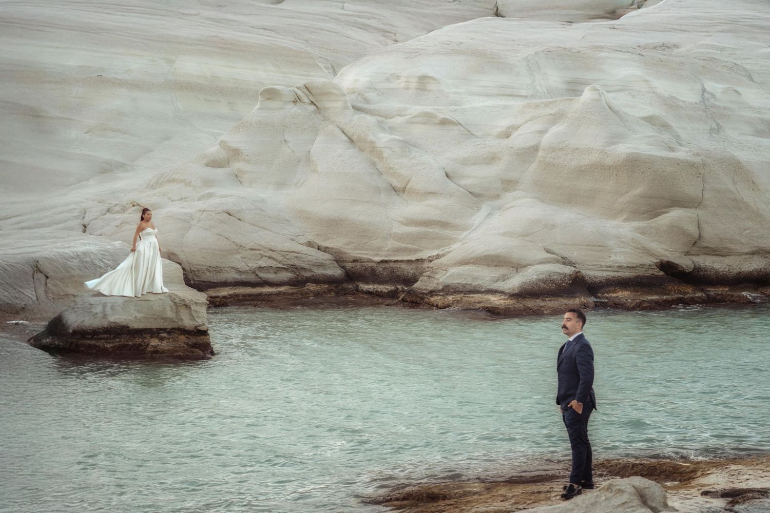 Elegant wedding scene with white cliffs and ocean backdrop.