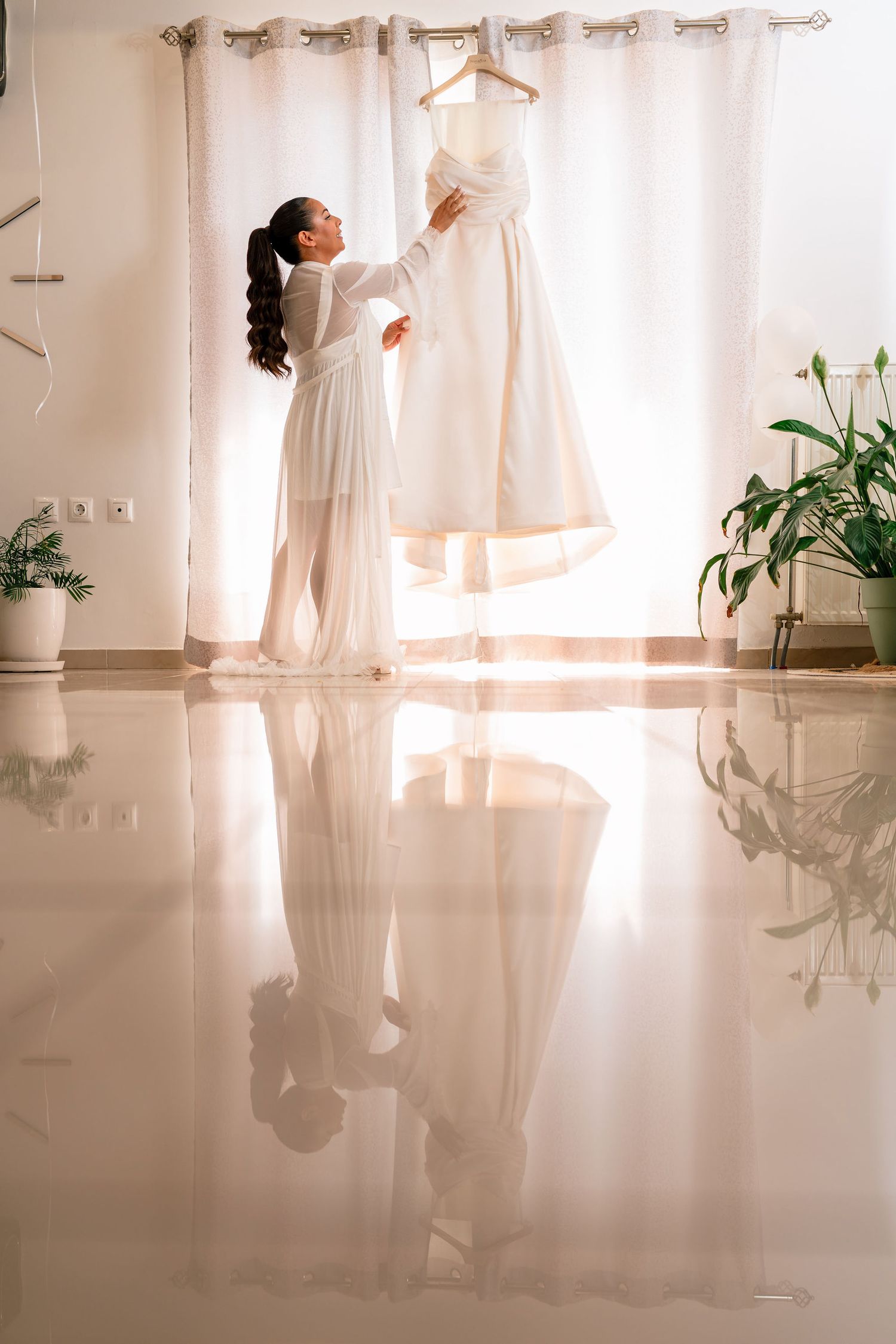 Sunlit room with white curtains and reflective floor during preparation.