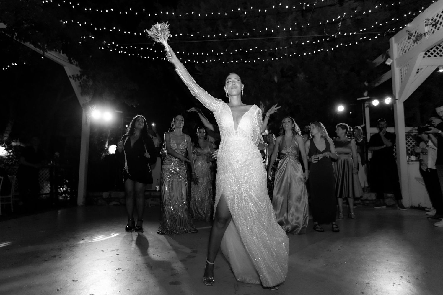 Silhouettes of dancers celebrating under a starry canopy of lights at an outdoor venue.