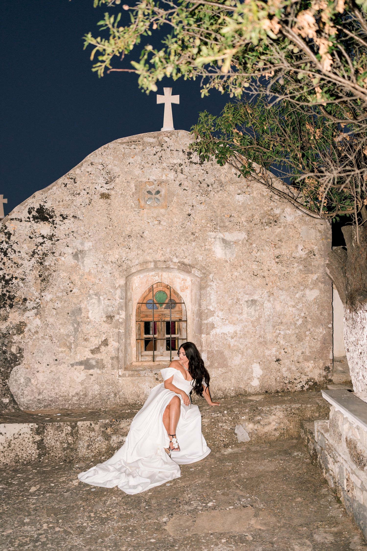 Romantic bridal portraits against an old stone wall at night.