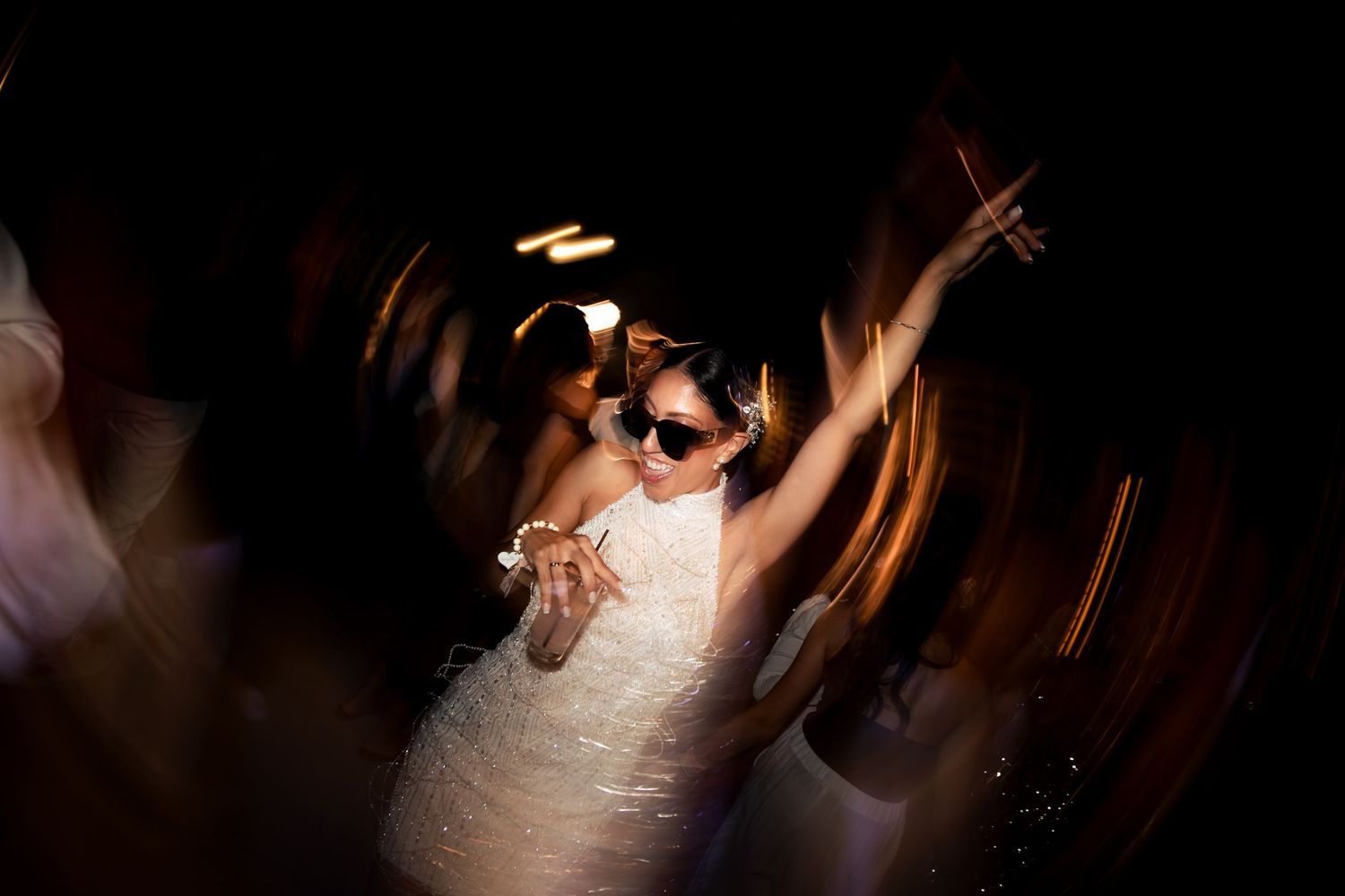 Abstract party photography with swirling light trails and dynamic movement.