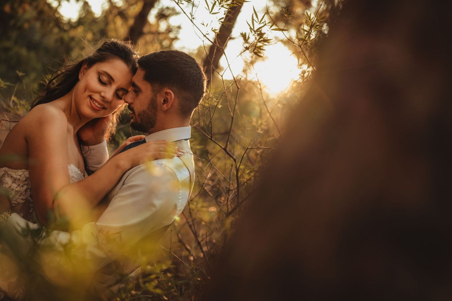 Couple embraces during golden hour in a romantic outdoor setting.