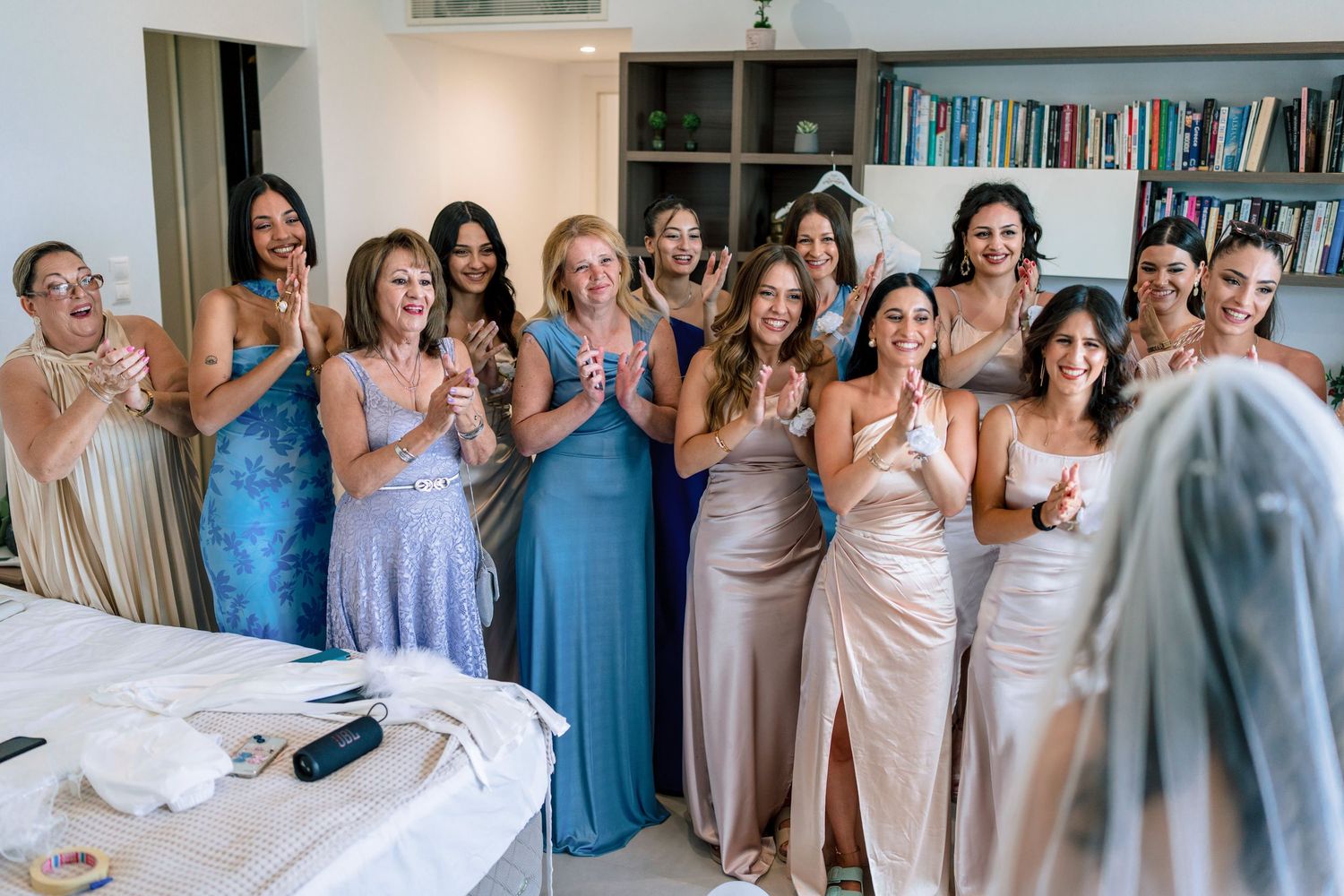 Wedding party group photo with bridesmaids in blue and neutral colored dresses.