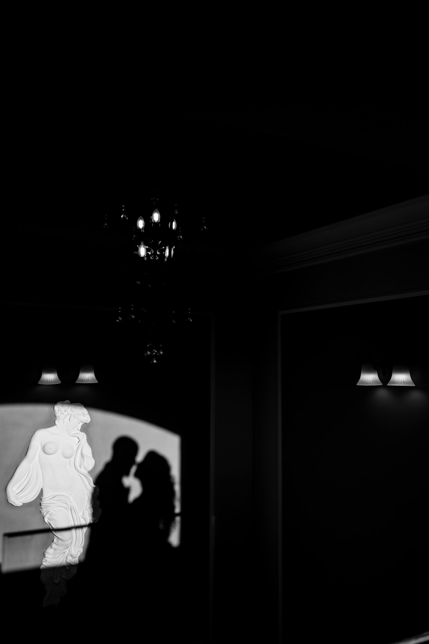 Black and white image showing shadows and light patterns in a dark interior space.