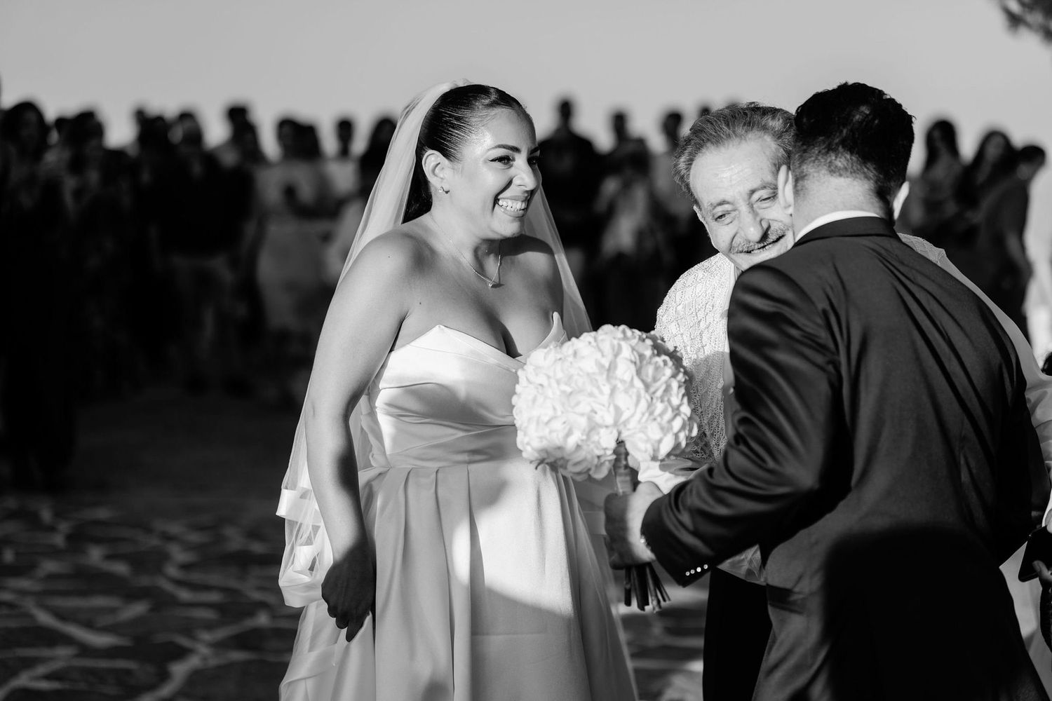 Black and white photo of wedding guests dancing at reception.