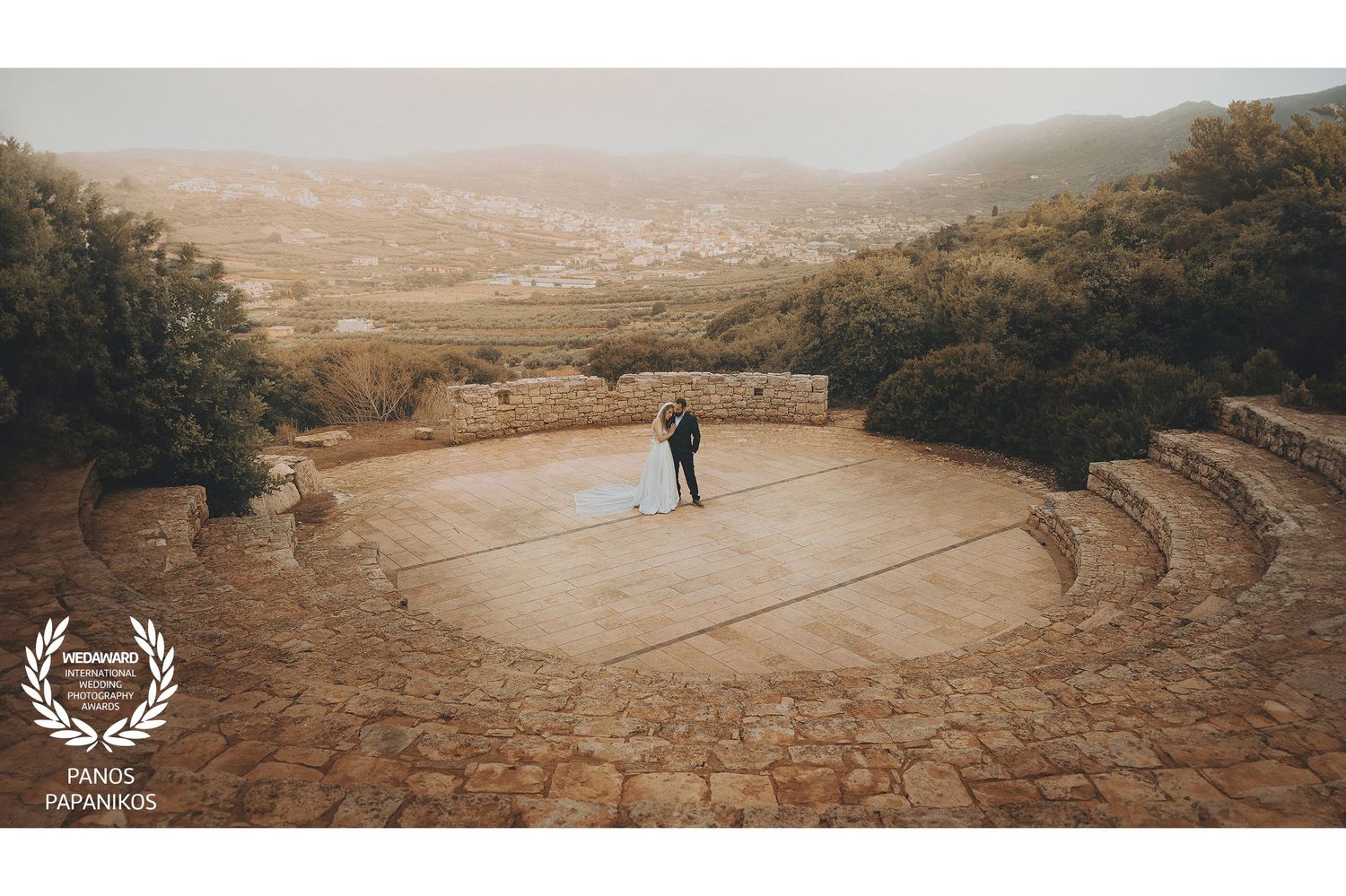 Panoramic desert wedding scene with dramatic mountain backdrop.