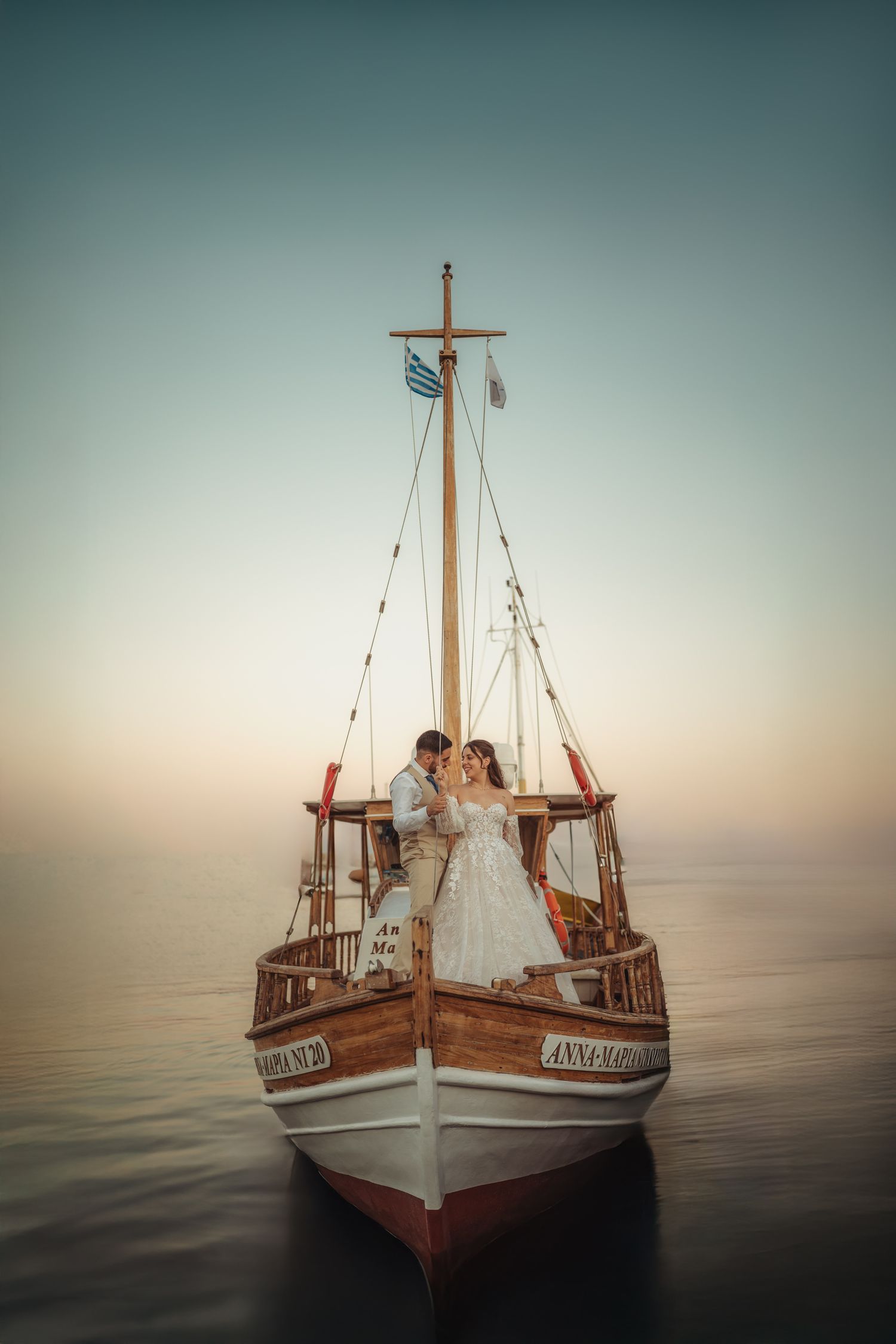 Vintage wooden boat floating on calm waters during sunset.