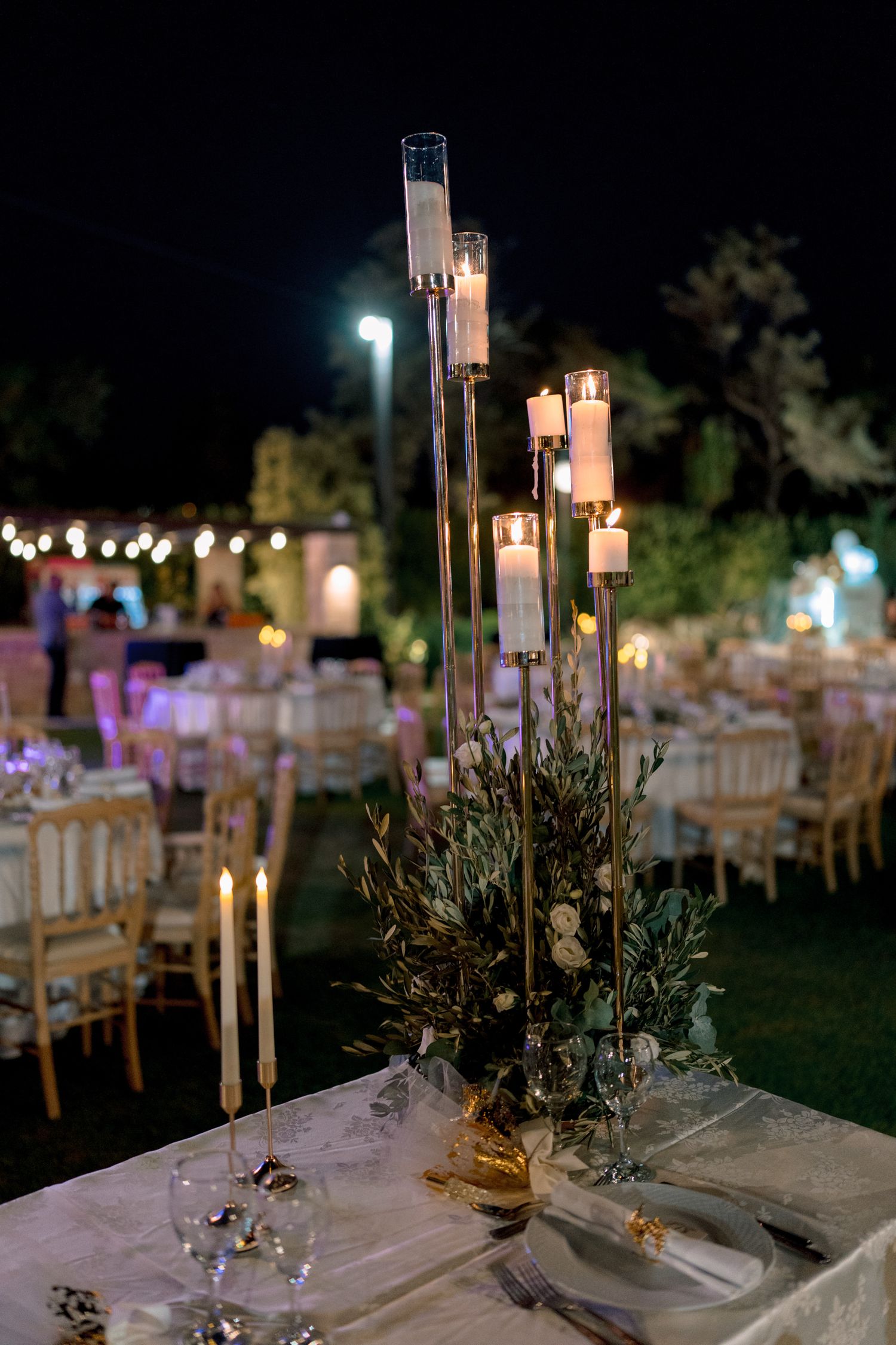 Romantic outdoor wedding reception with lanterns and string lights creating ambient evening atmosphere.