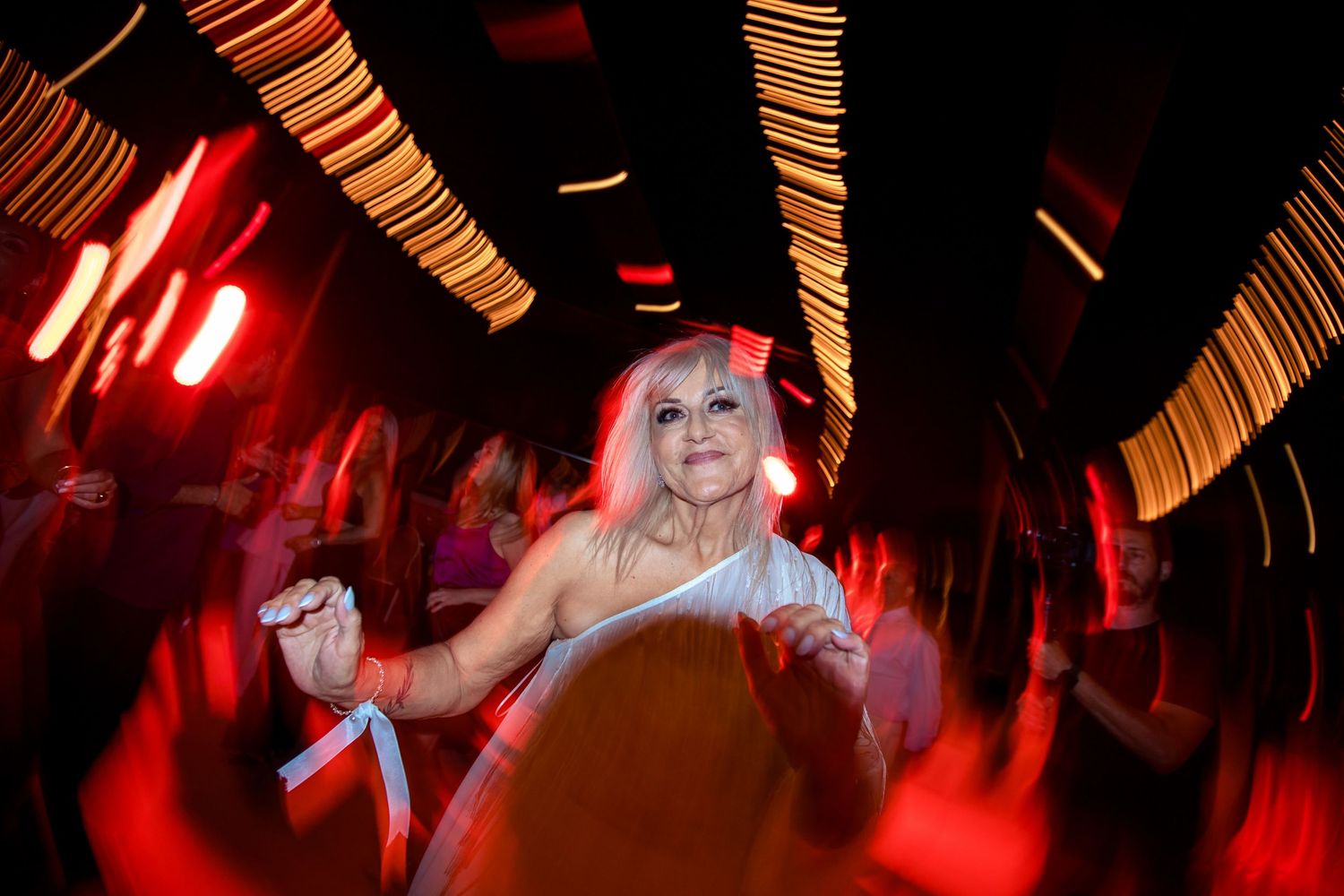 Dance floor bathed in dramatic red lighting during evening celebration.