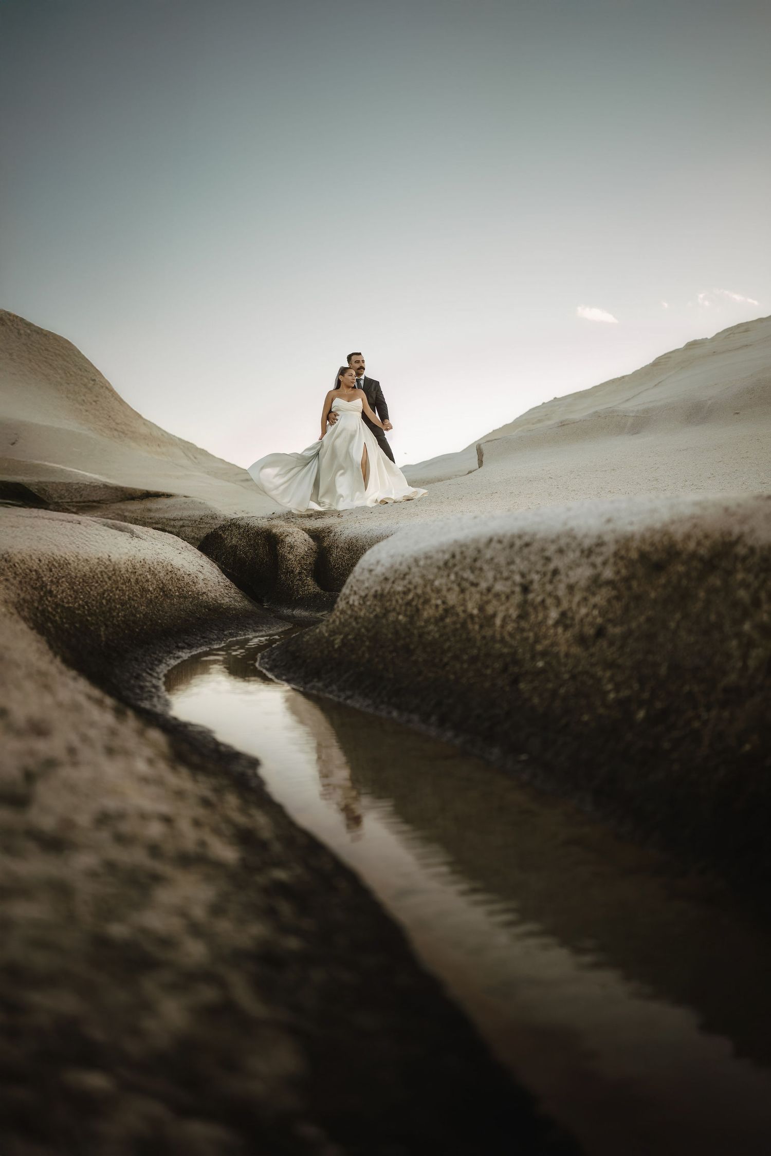Dramatic landscape with winding path through rocky terrain at sunset.