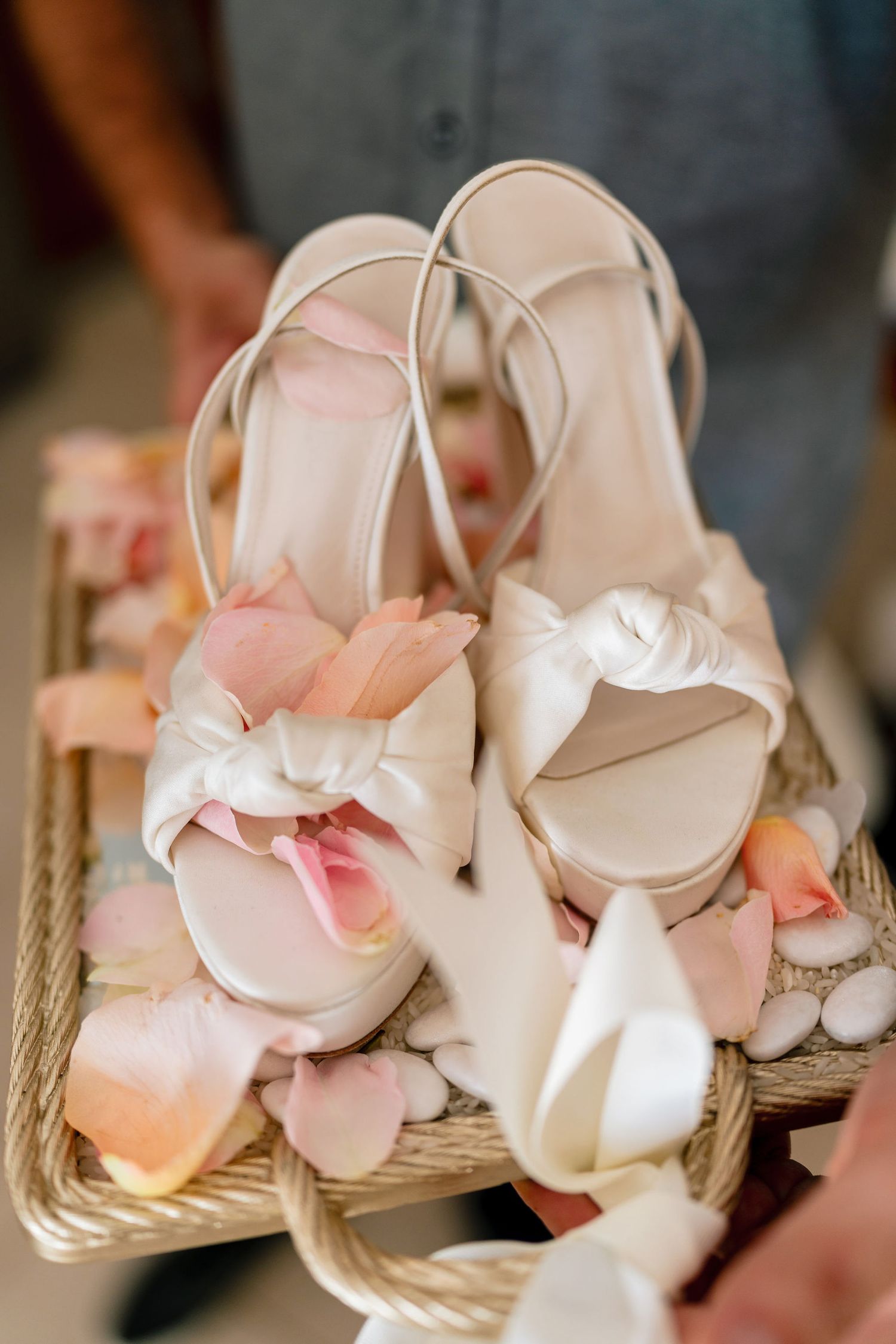 Delicate white and pink wedding shoes arranged with floral details.