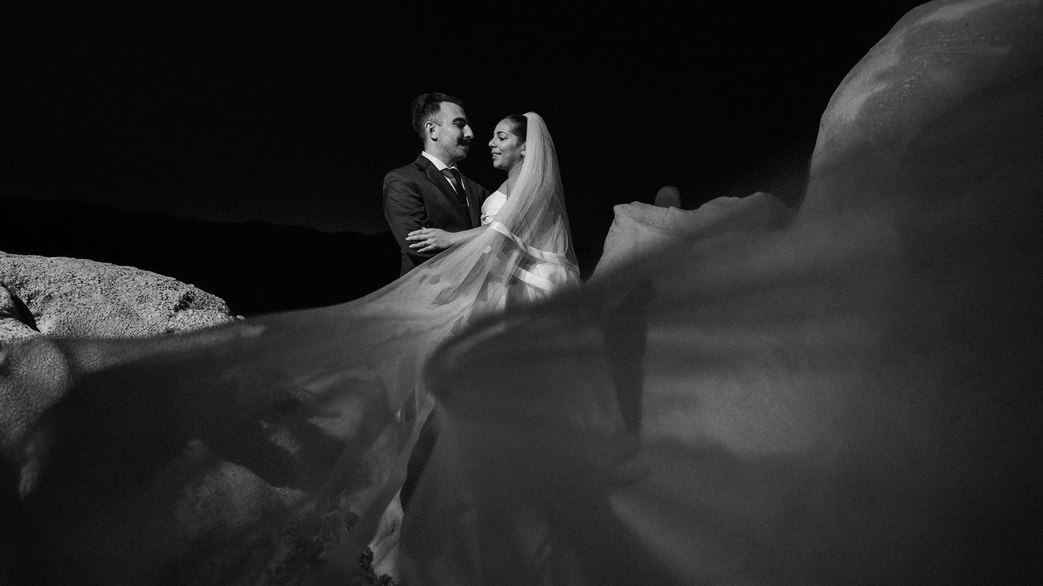 Silhouette of a couple embracing against a dark background.