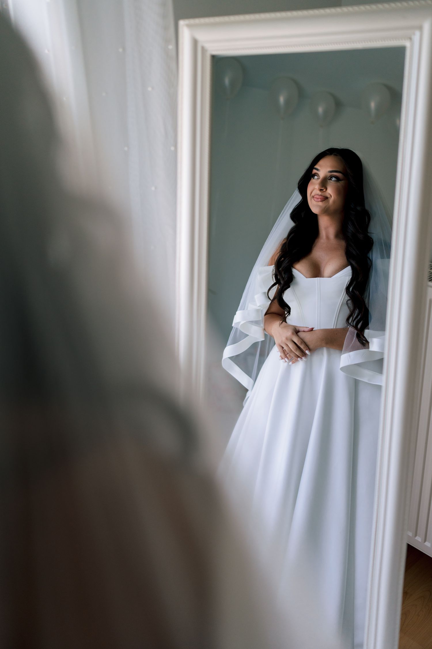 Bridal boudoir photoshoot sequence in white flowing fabric by window light.