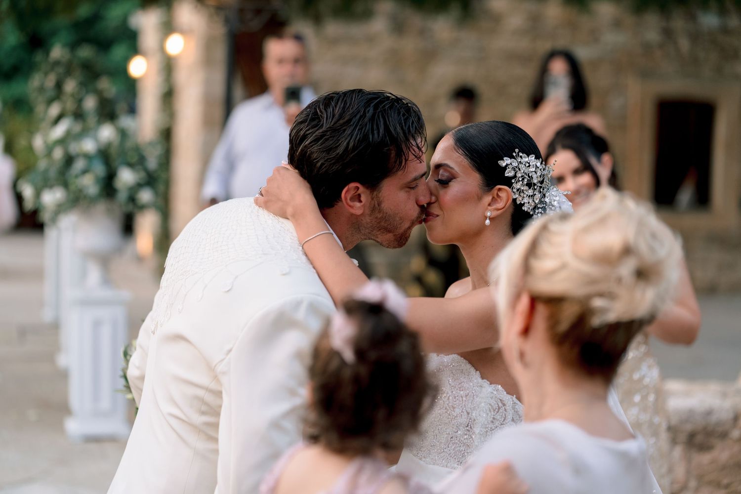 Newlyweds embrace in a romantic moment during their outdoor garden wedding.