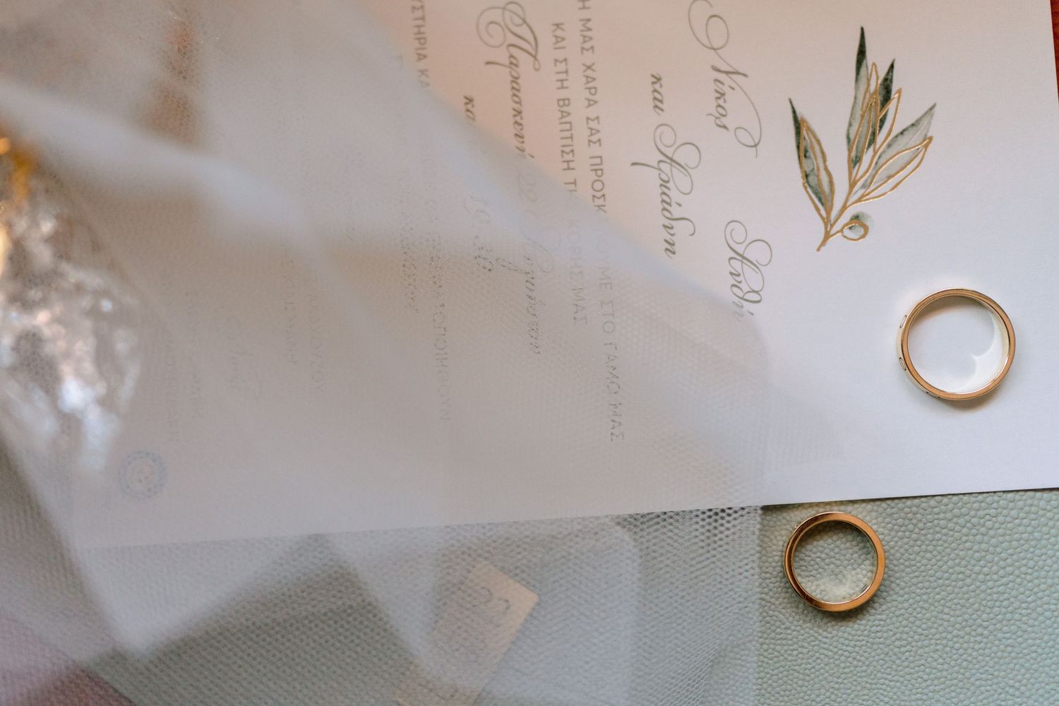 Wedding stationery with elegant calligraphy and gold ring details.