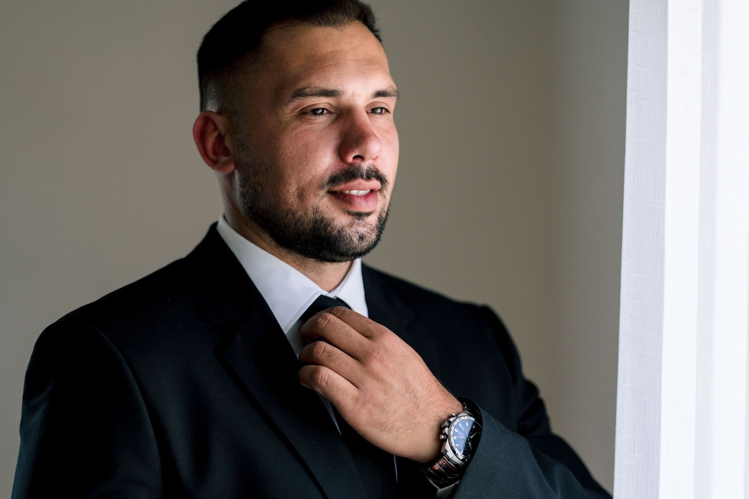 Side profile portrait in a classic black suit.