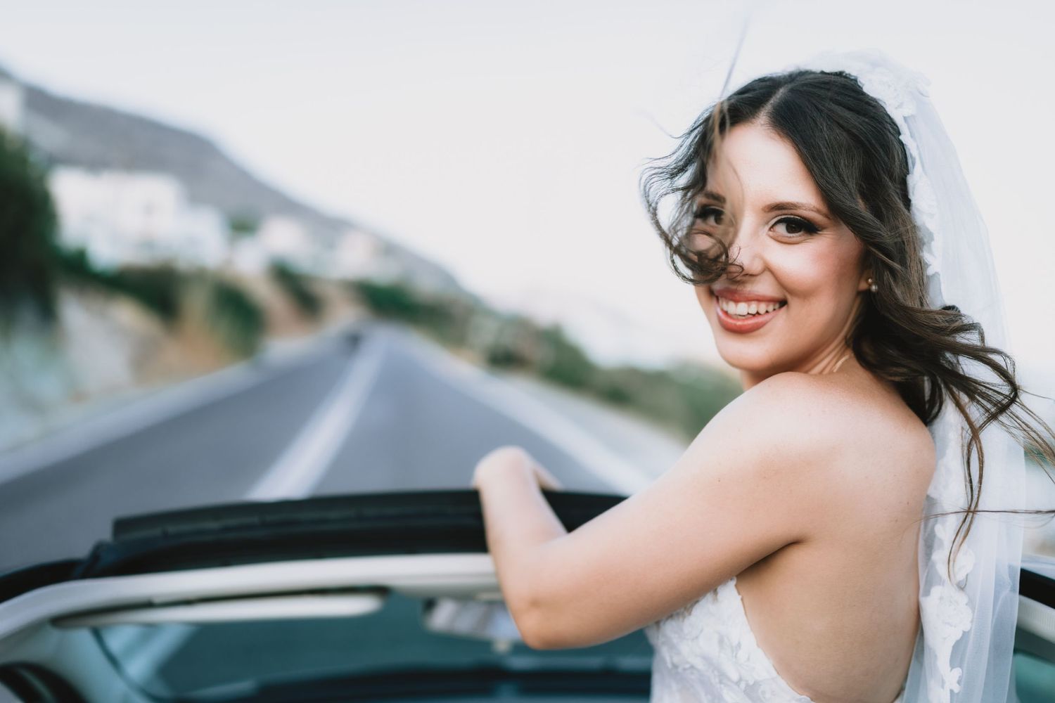 Candid wedding photos captured through a car window with scenic mountain views.