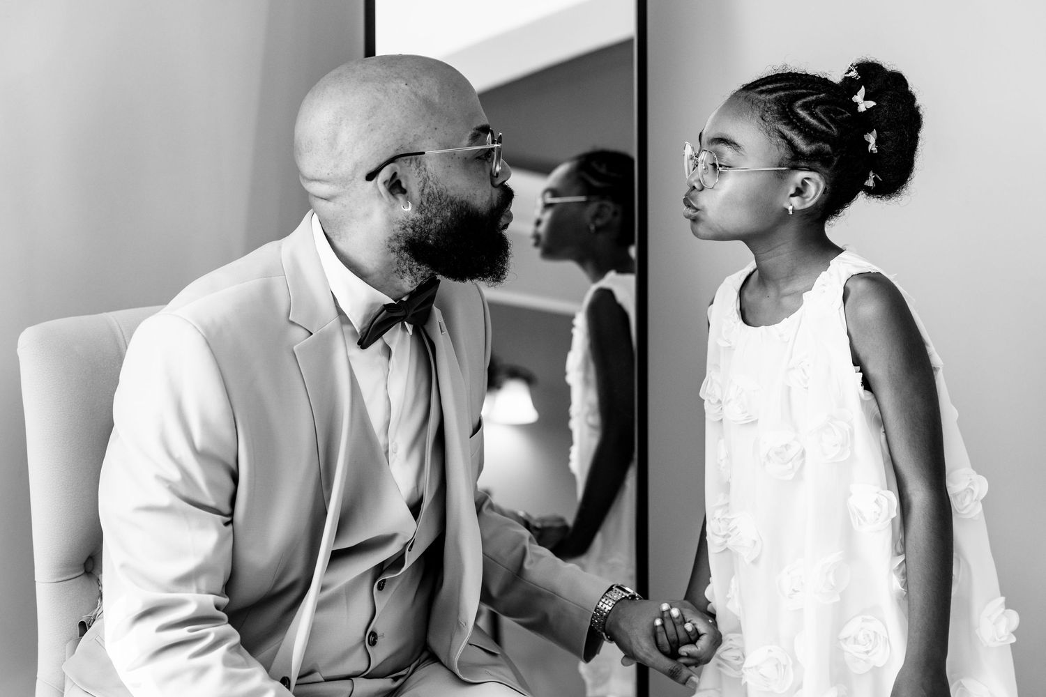 Wedding party members share candid laughing moments in black and white photography.