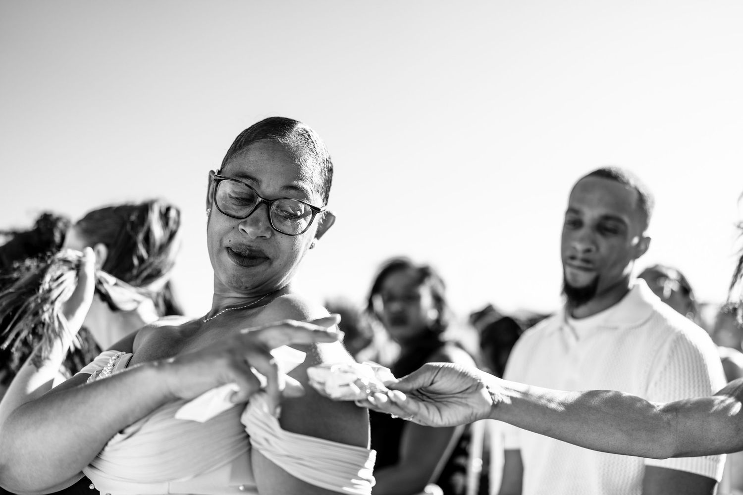 Black and white candid shots of wedding guests celebrating and dancing.
