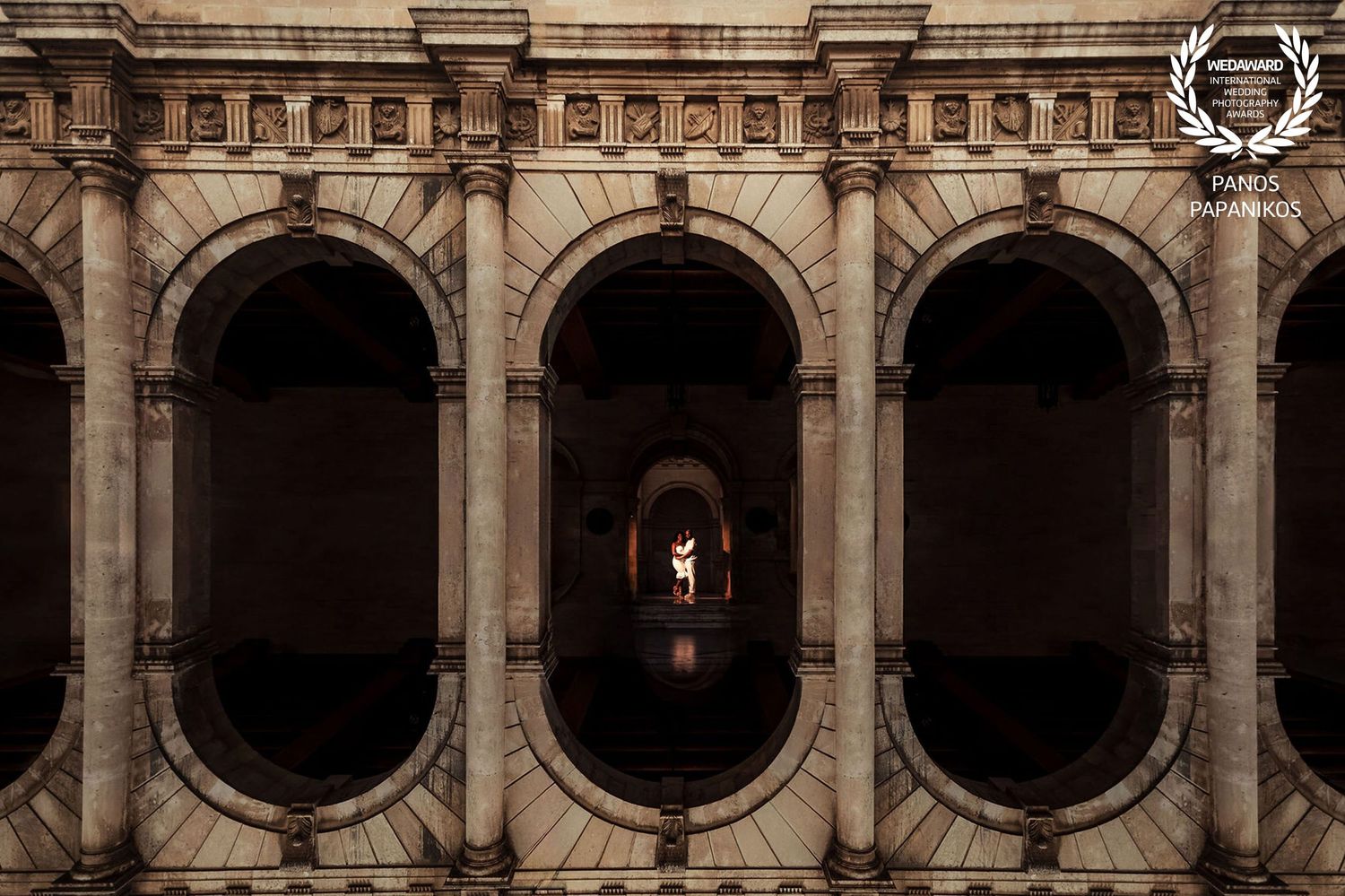 Historic stone archway corridor with classical architecture and dramatic lighting.