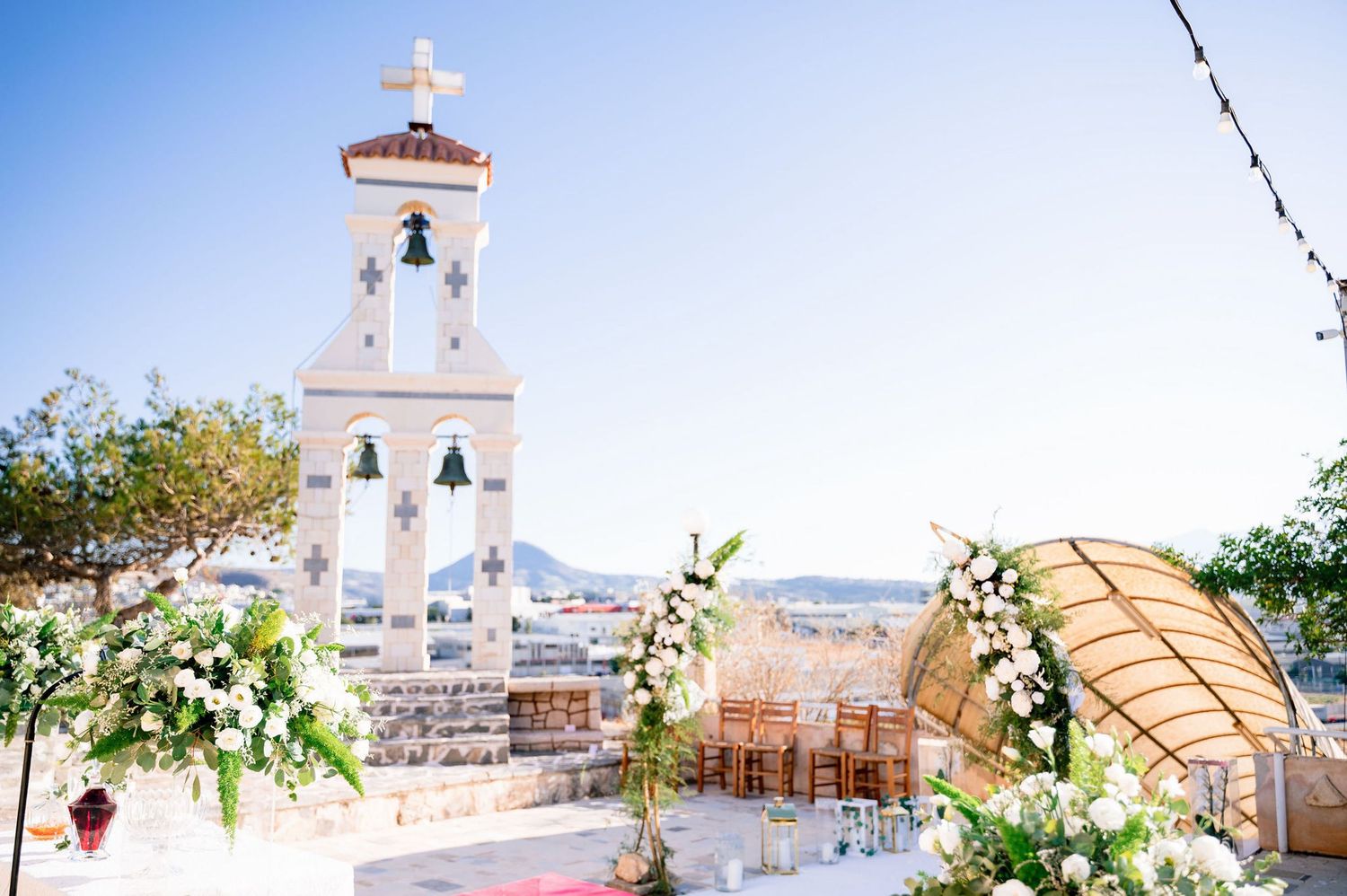 Mediterranean church exterior with white architecture and blue sky in scenic coastal setting.