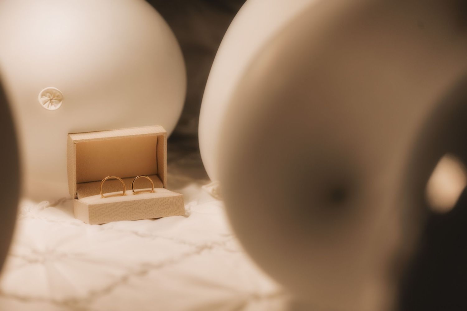 Blurred wedding preparation details in warm sepia tones.