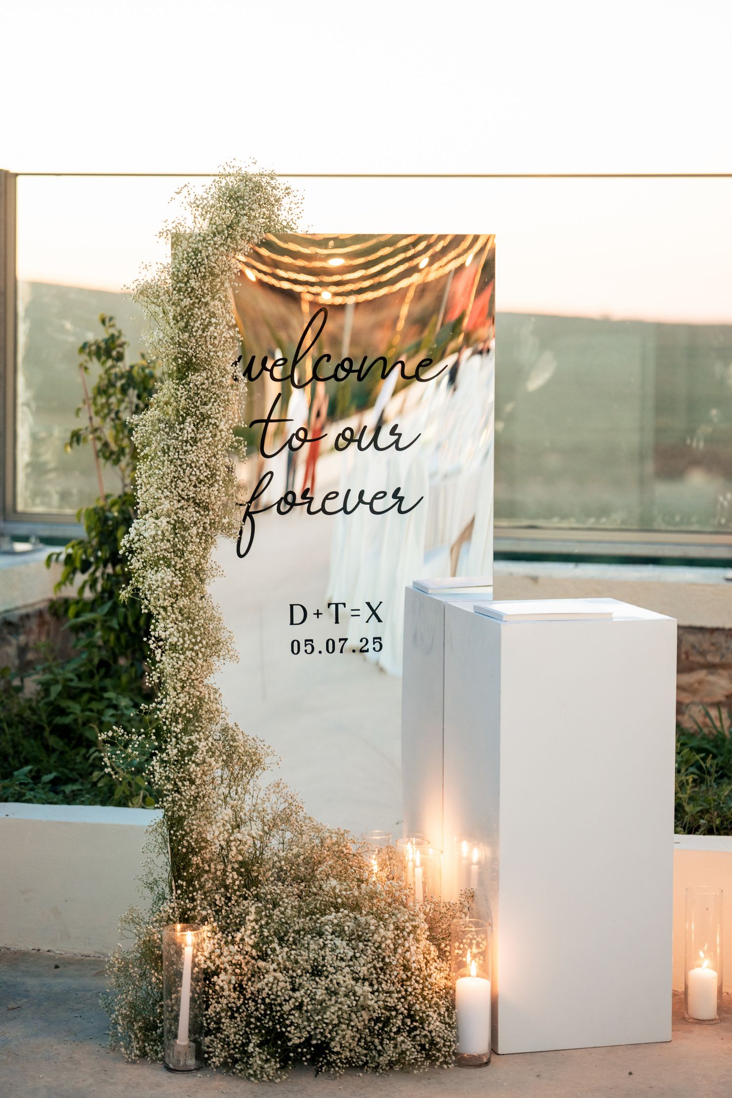 Elegant white wedding welcome sign display with candles and floral arrangements.