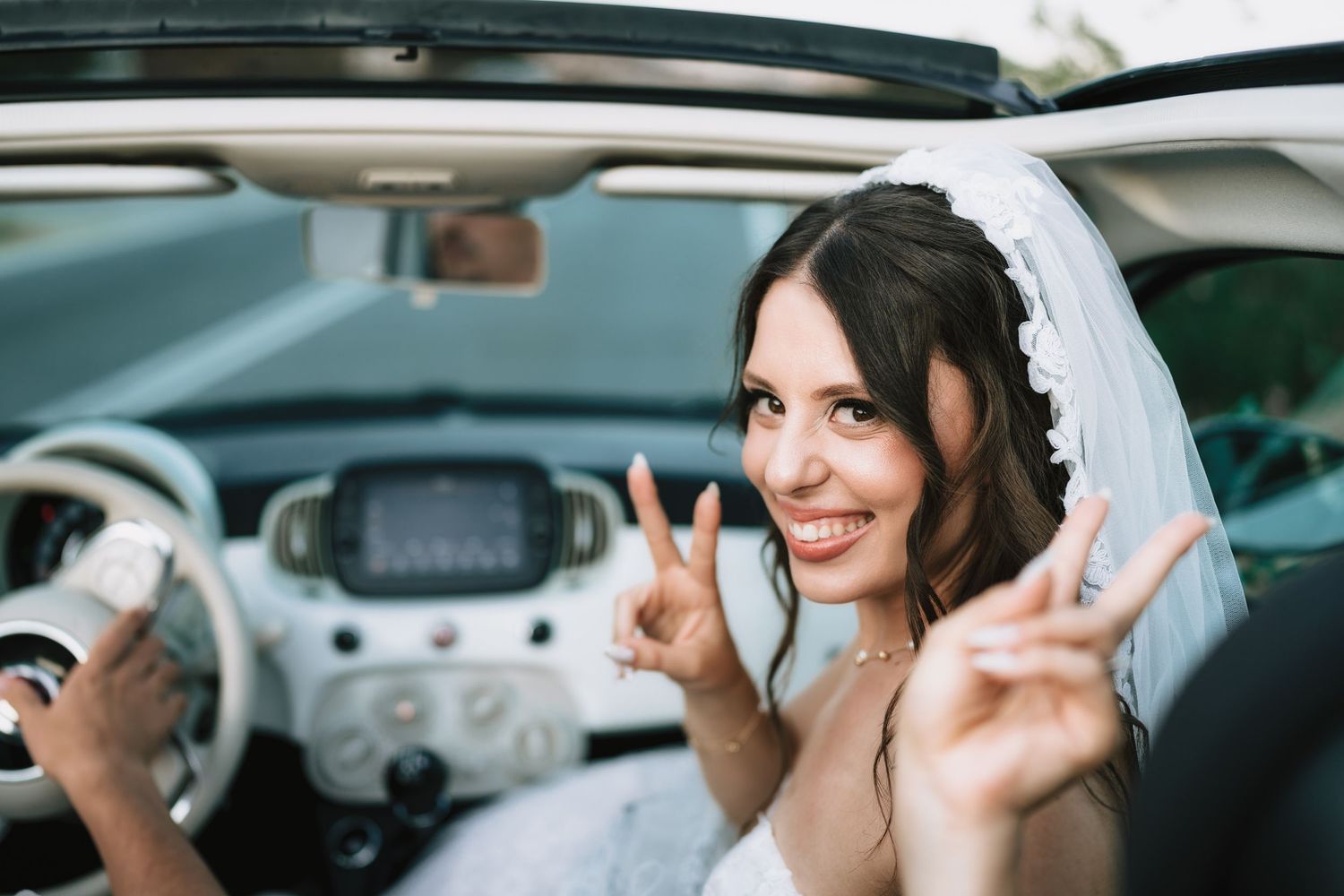 Candid moments captured through car window during wedding day.