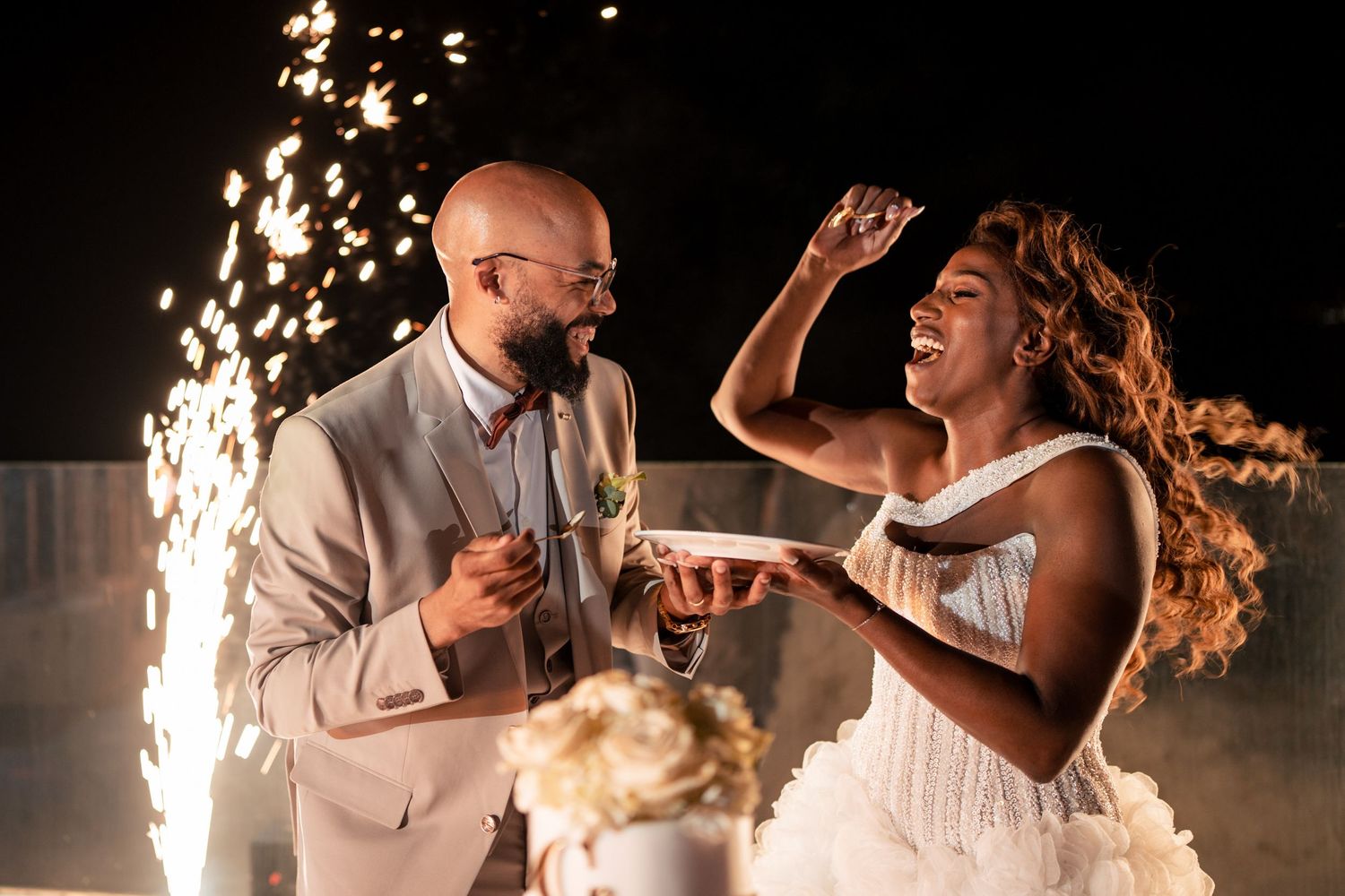 Couple shares a romantic dance moment surrounded by sparkler effects.