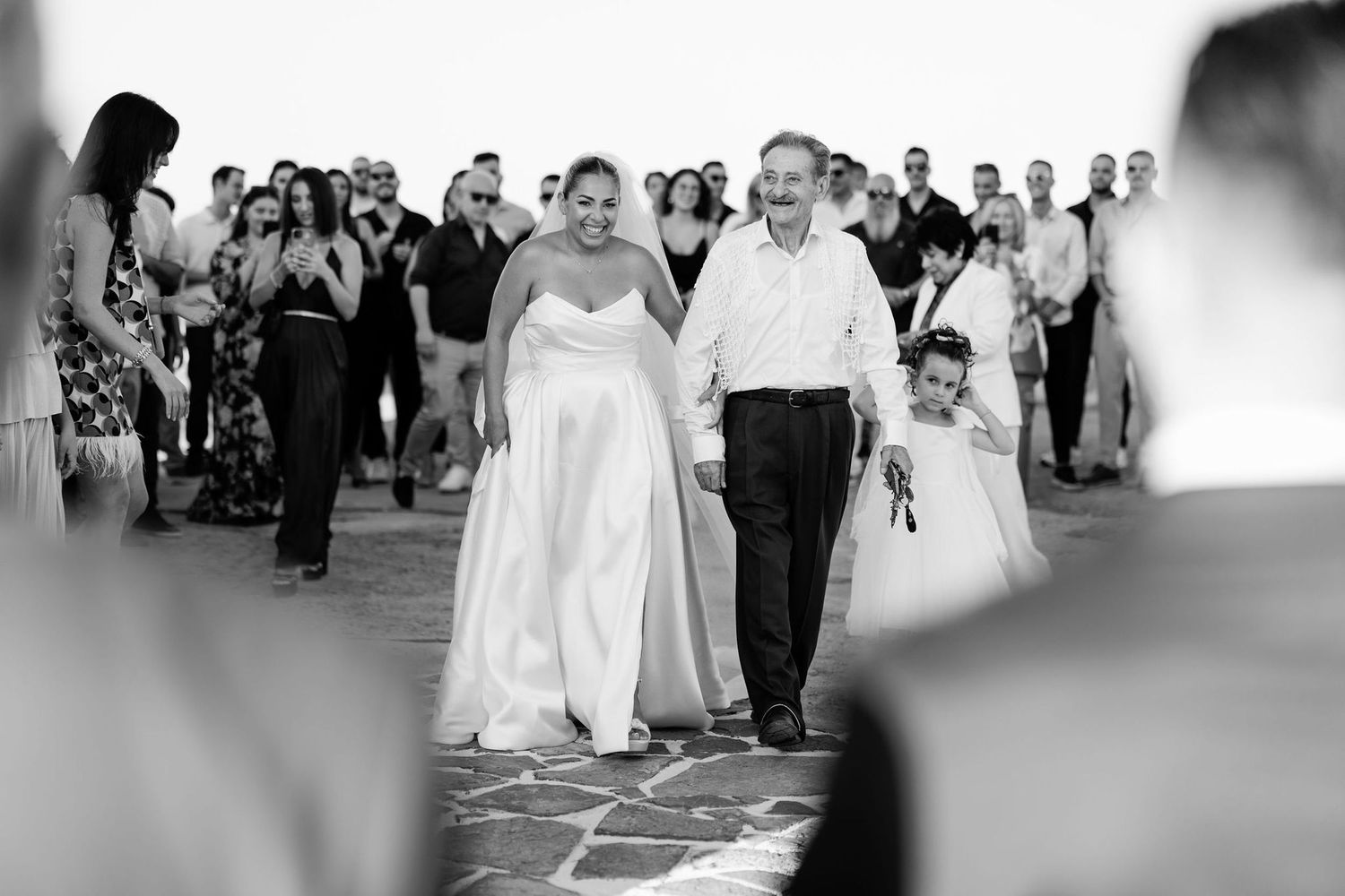 Wedding guests gather outdoors for a celebration ceremony.