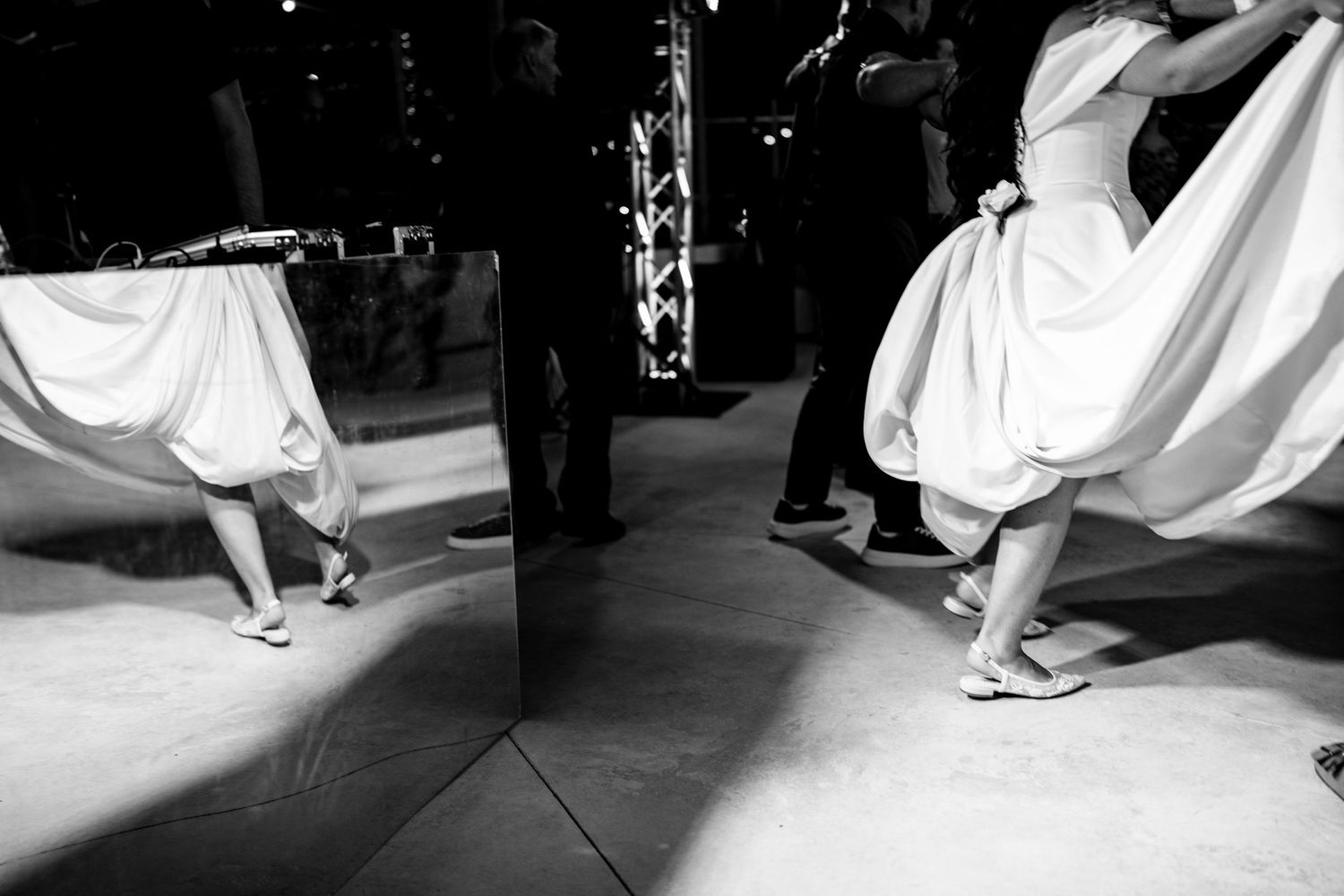 Black and white shot of dancing feet at an elegant wedding reception.