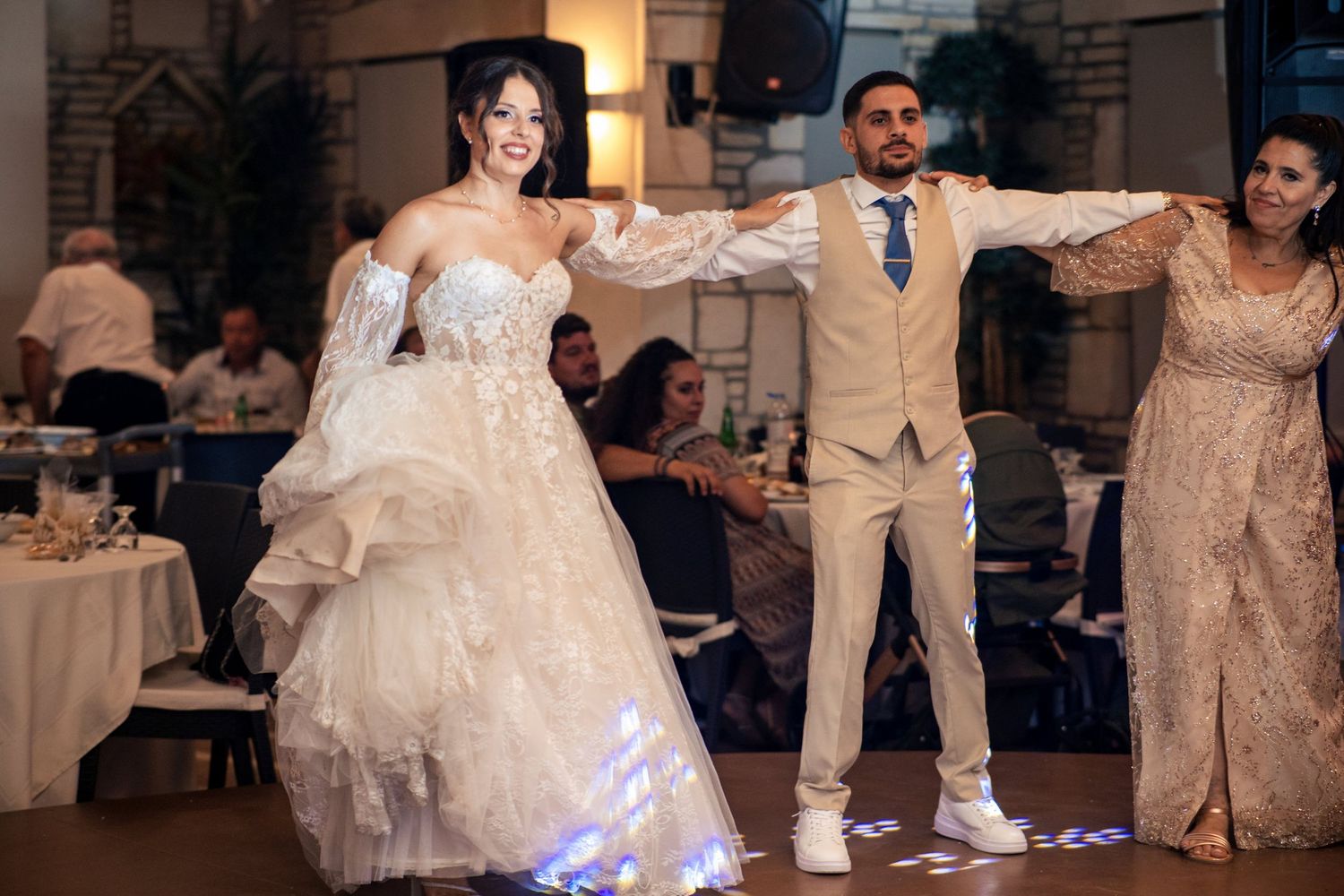 Wedding party members dance together on reception dance floor.