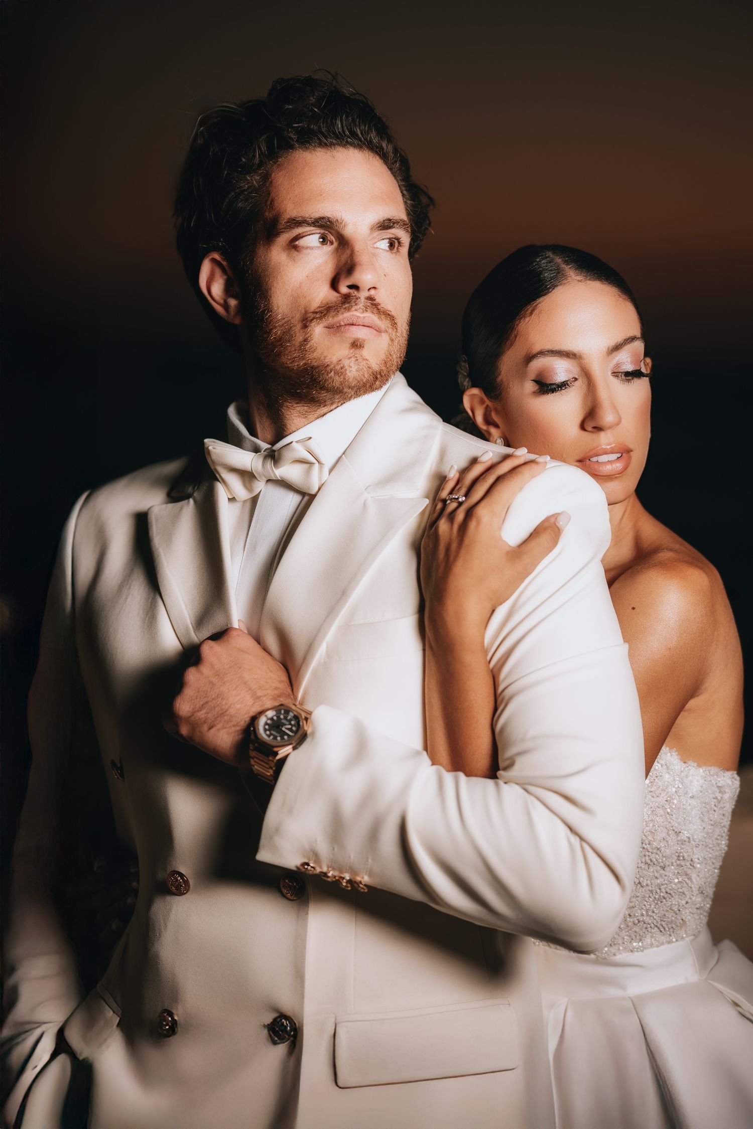Intimate close-up wedding portraits with warm lighting and white formal attire.