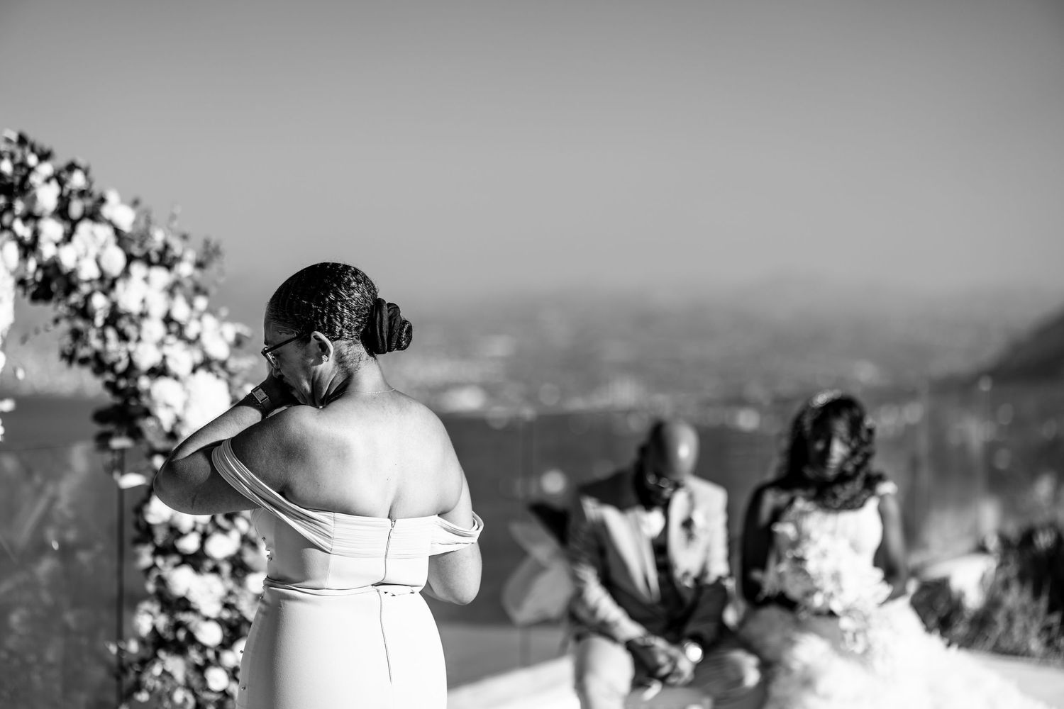 Wedding ceremony overlooking a scenic mountain landscape with floral decorations.