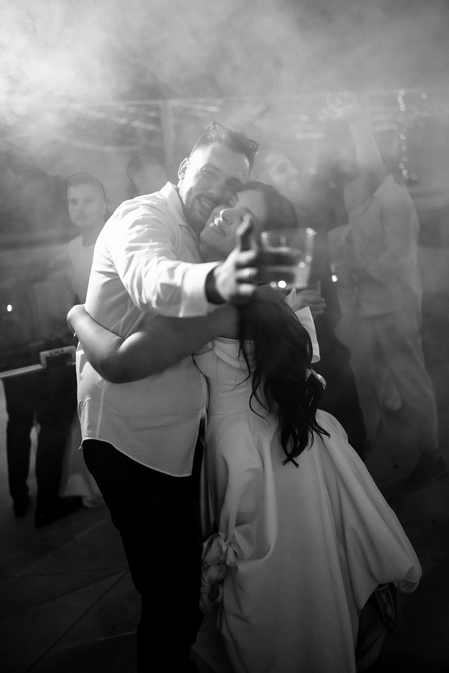 Black and white dance floor moment with couple dancing under twinkling lights.