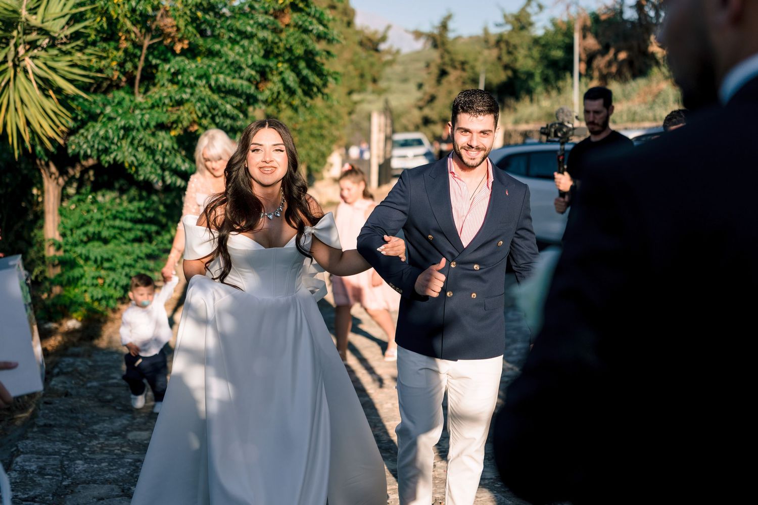 Wedding guests celebrating outdoors with sparklers during a joyful evening celebration.