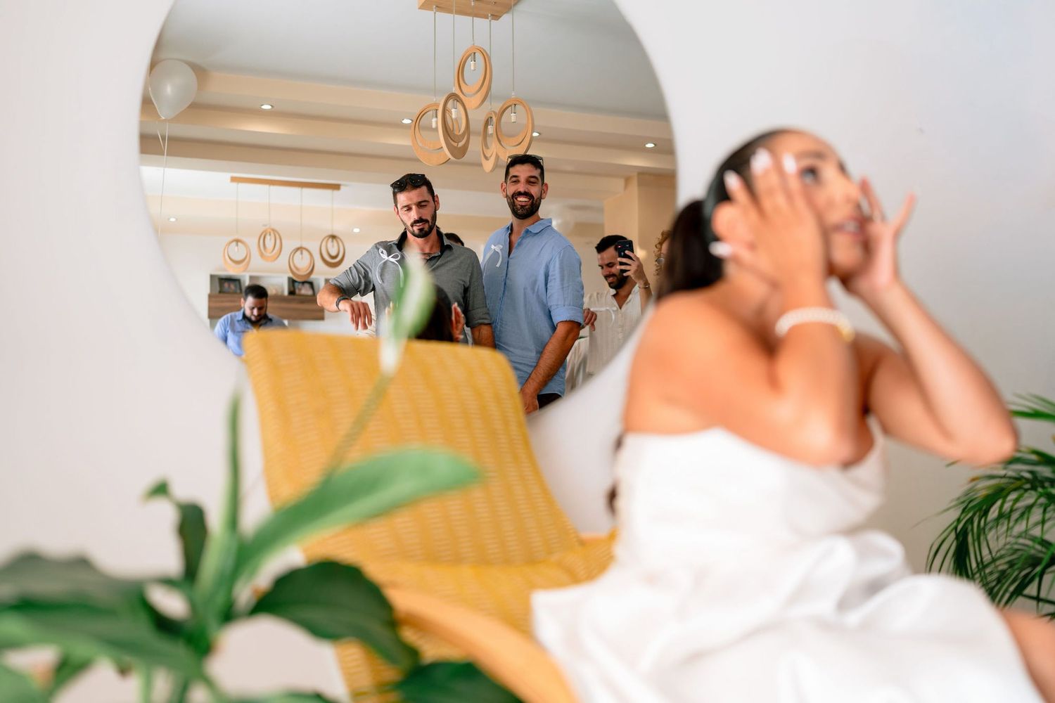 Wedding party members interacting in a bright indoor venue with decorative elements.