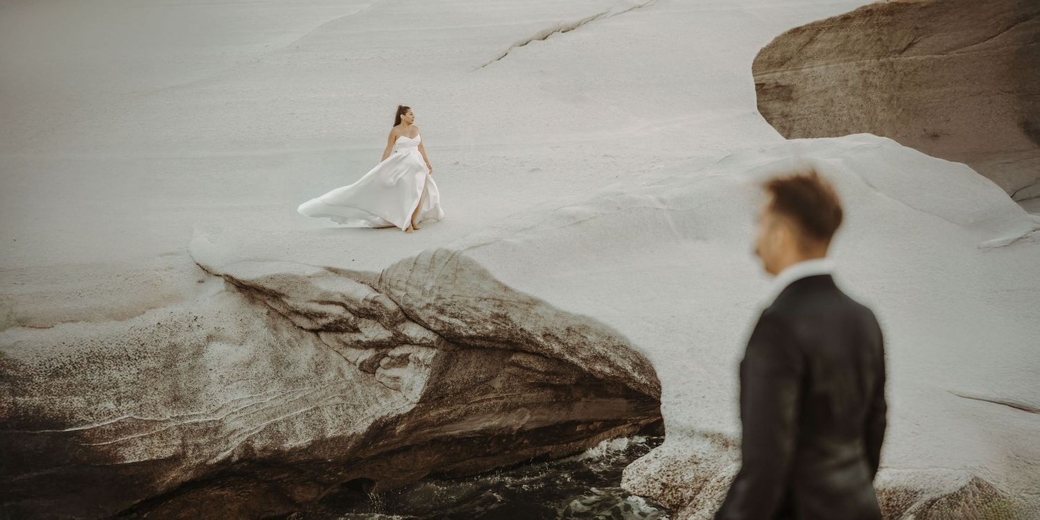 Artistic wedding photography on rocky terrain with dramatic landscape views.