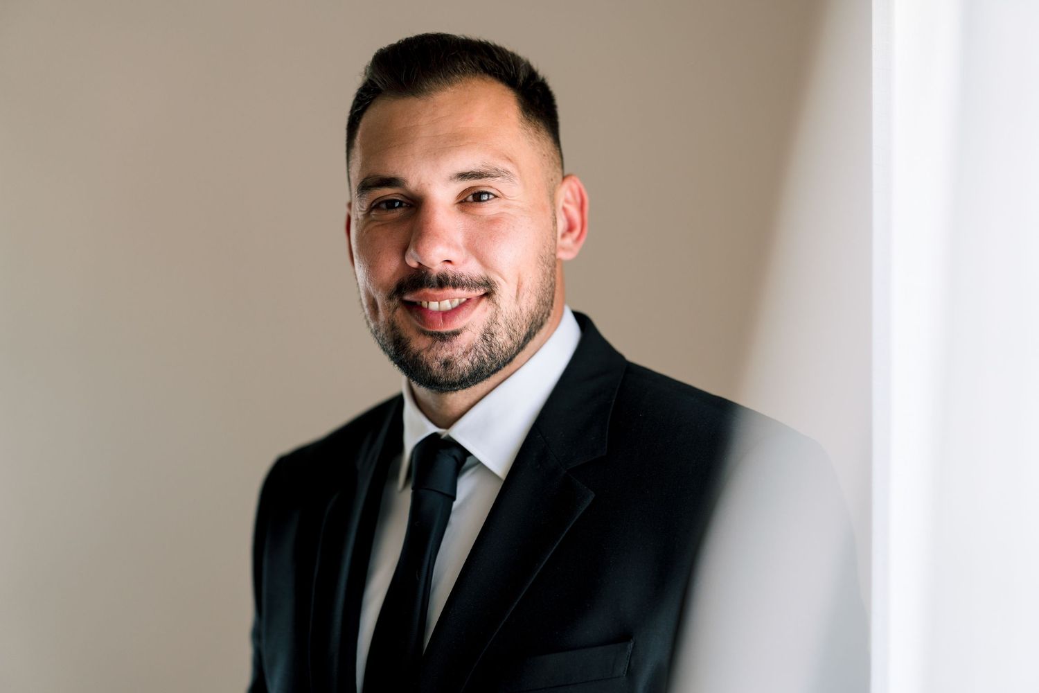 Professional portrait in formal attire against a neutral background.