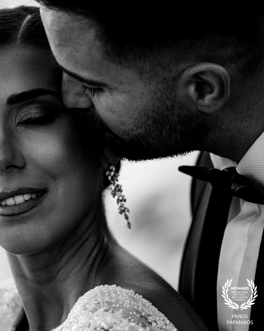 Black and white intimate wedding portrait showing tender romantic moment between couple.