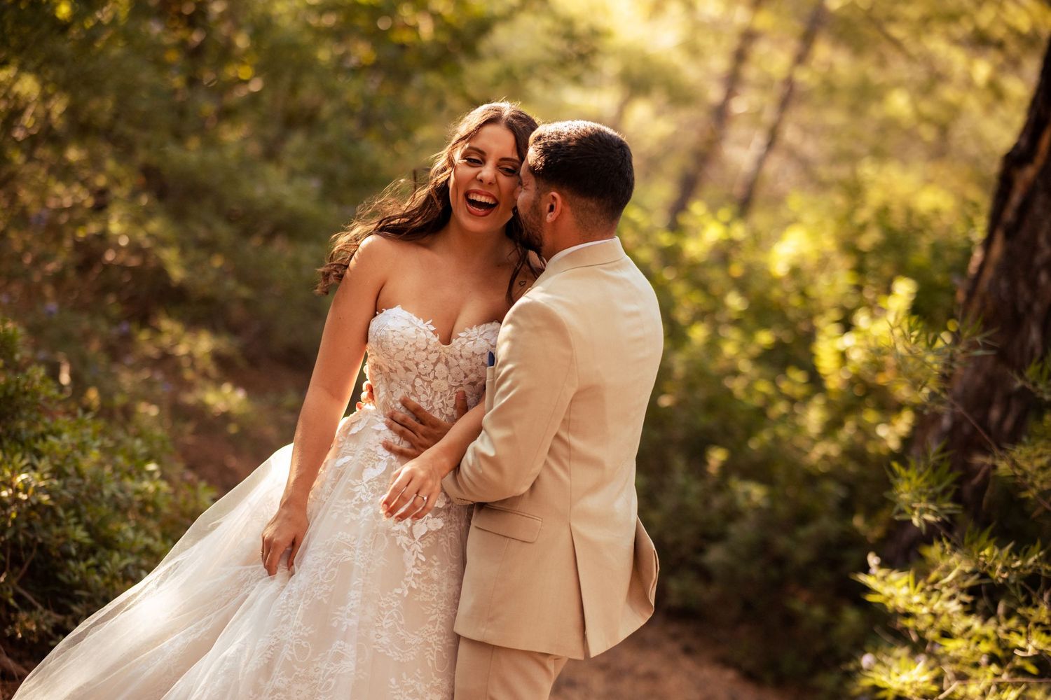 Romantic couple shares intimate moment in sunlit forest setting.