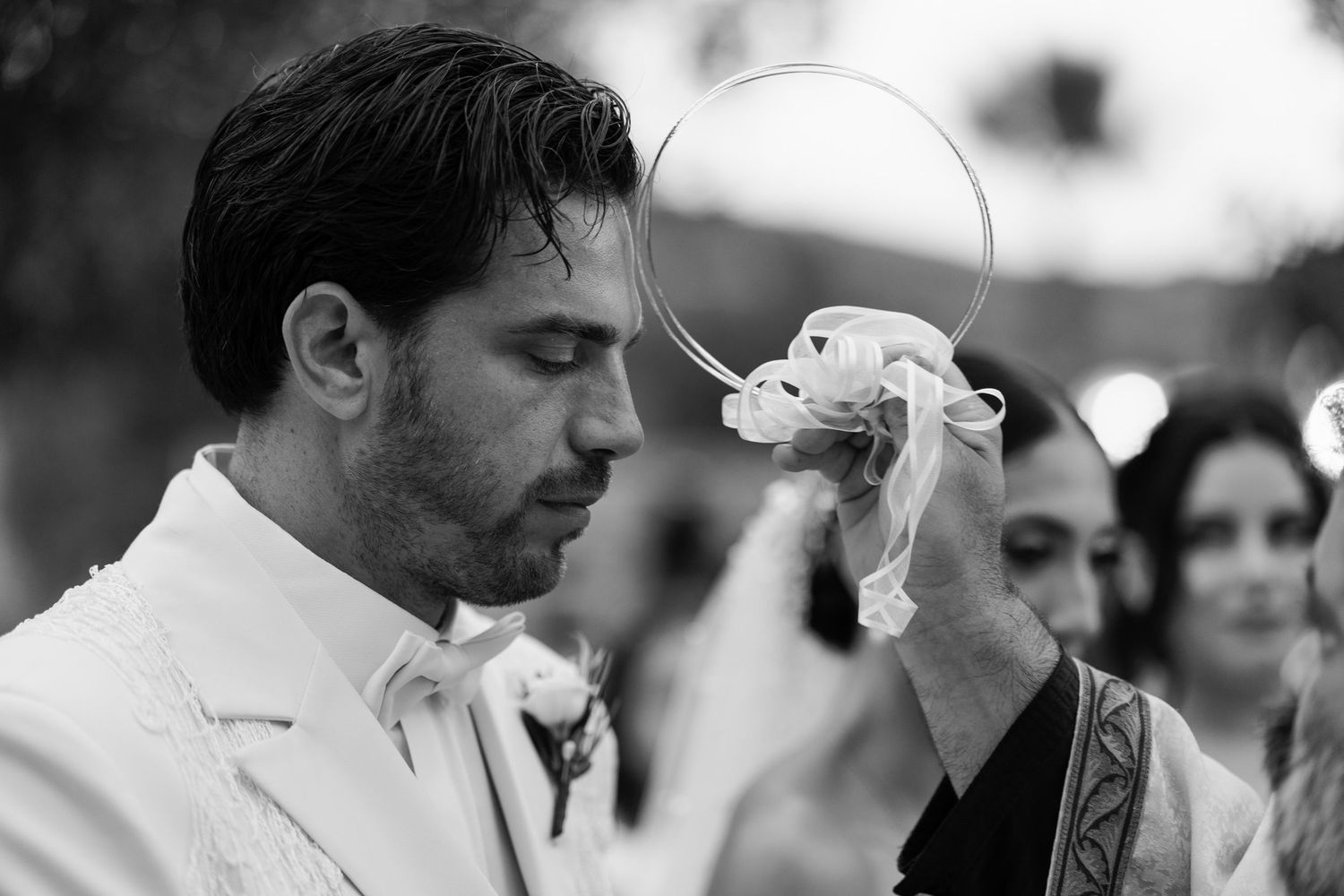 Black and white wedding ceremony photo showing formal attire and elegant details.