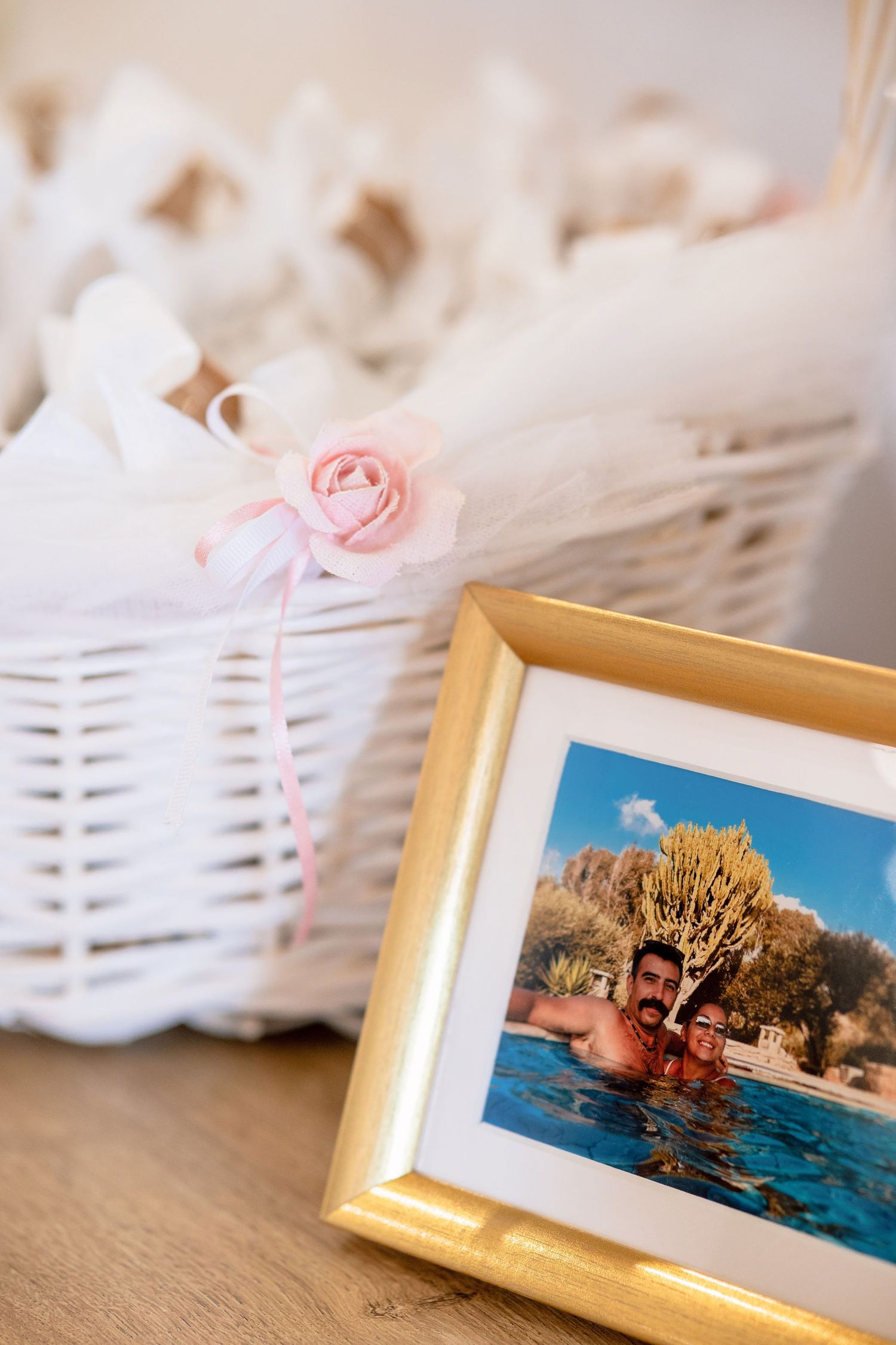 Framed vacation photos displayed alongside white decorative baskets.