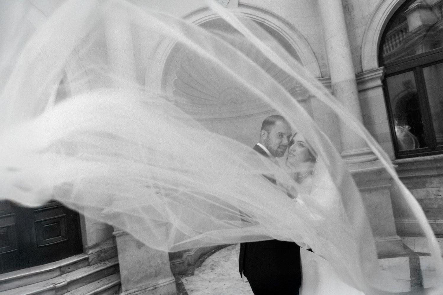 A flowing white veil catches the light in an elegant wedding photo sequence.